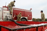 Spcs. Graydon Irish, Justin Wilkinson and Kyle Vanatta, firefighters with the Montana National Guard's 1051st Fire Fighting Tactical Group, train on Camp Ripley, Minnesota. The Soldiers were familiarizing themselves with operating a pump and adjusting water pressure before mobilizing overseas in 2021.