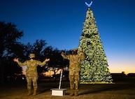Air Force Brig. Gen. Caroline M. Miller (left), 502d Air Base Wing and Joint Base San Antonio commander, and U.S. Air Force Chief Master Sgt. Wendell Snider (right) 502nd Air Base Wing and Joint Base San Antonio command chief, participate in the live streamed tree-lighting ceremony at JBSA-Lackland Dec. 2.