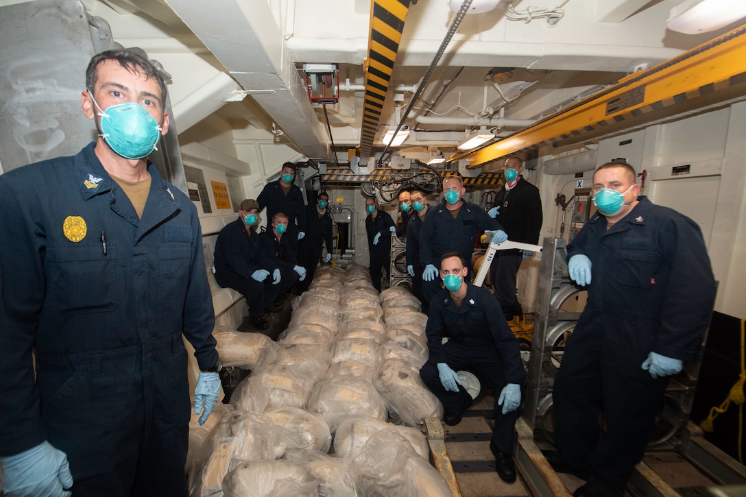 ARABIAN SEA (Dec. 4, 2020) Sailors assigned to the guided-missile destroyer USS Ralph Johnson (DDG 114) pose with seized narcotics following a visit, board, search, and seizure operation in support of Combined Maritime Forces (CMF) Combined Task Force (CTF) 150 in the Arabian Sea, Dec. 4. CMF is a multinational maritime partnership which exists to counter illicit non-state actors on the high seas, promoting security, stability and prosperity in the Arabian Gulf, the Red Sea, Gulf of Aden, Indian Ocean and Gulf of Oman. CTF 150 conducts maritime security operations outside the Arabian Gulf to disrupt criminal and terrorist organizations, ensuring legitimate commercial shipping can transit the region free from non-state threats. (U.S. Navy Photo by Mass Communication Specialist 3rd Class Anthony Collier)