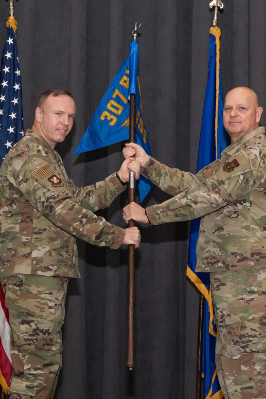 Photo of Airmen exchanging a unit guidon.