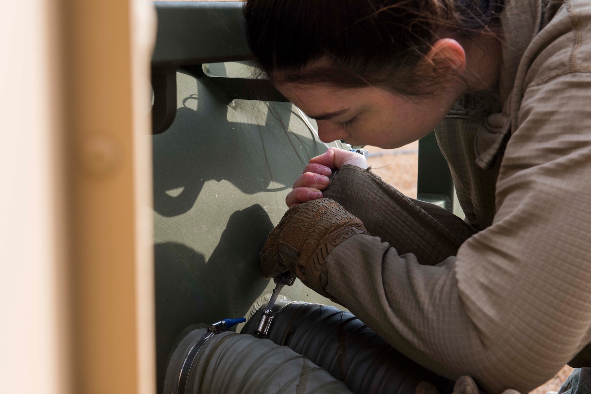 Airman screwing in a hose