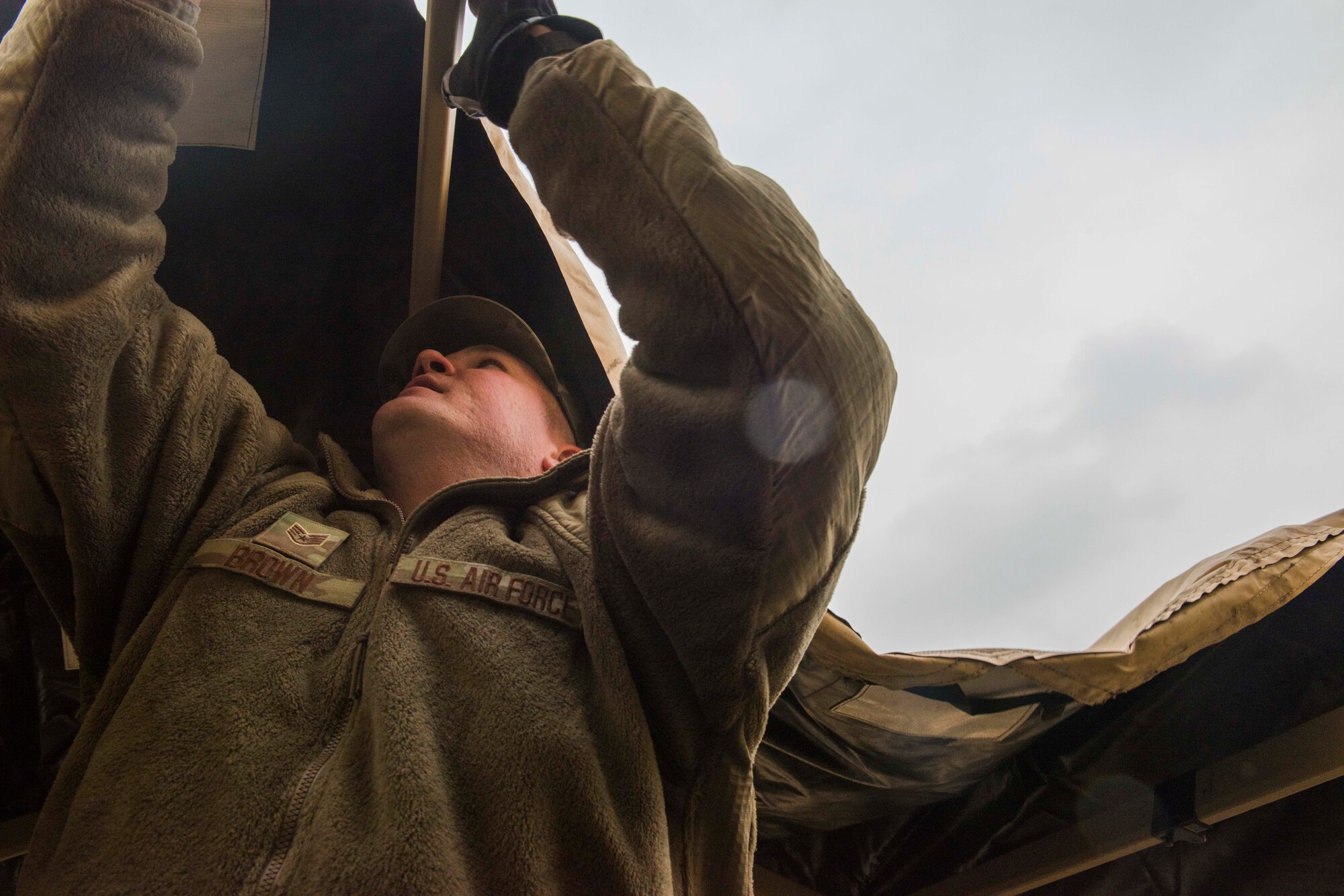 Airman holding up a tent cover