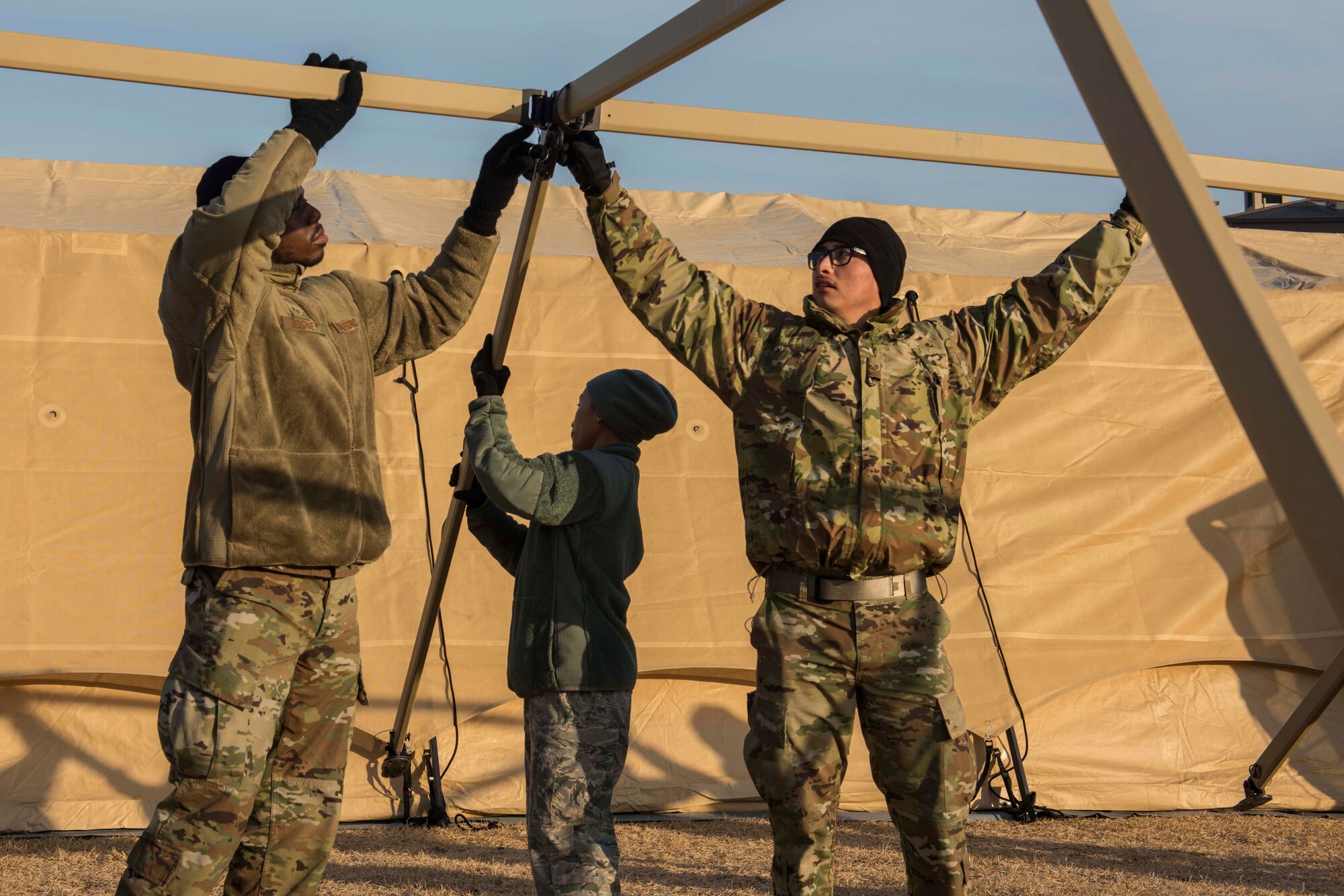 two men holding up a tent frame
