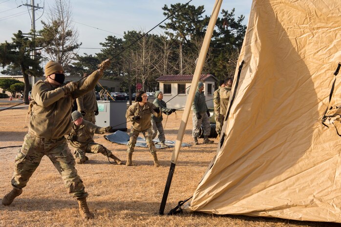 Airmen pulling a tent
