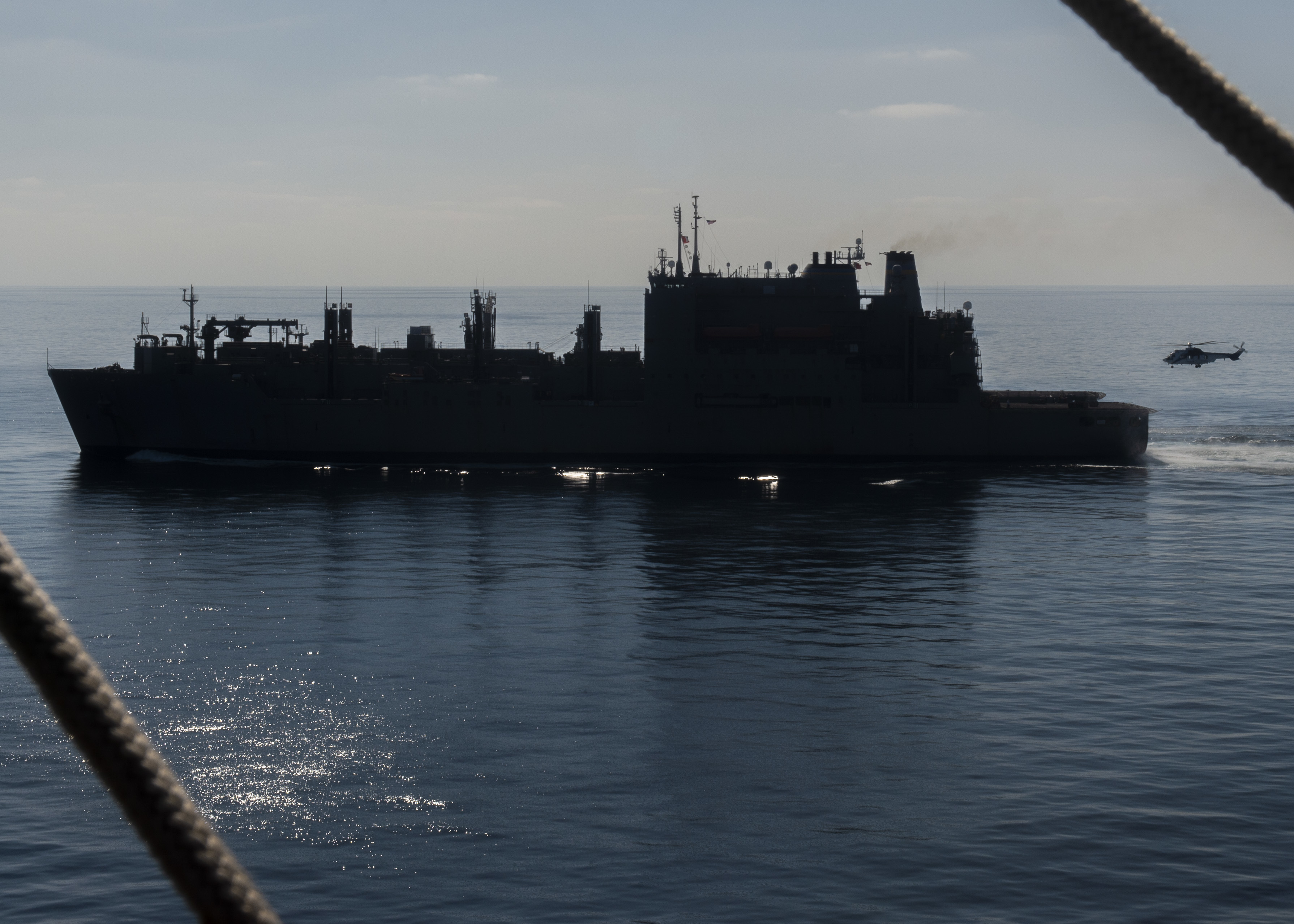 A Super Puma (EC-225) helicopter transports cargo from the Lewis and Clark-class dry cargo ship USNS Carl Brashear (T-AKE-7) to the aircraft carrier USS Nimitz (CVN 68).