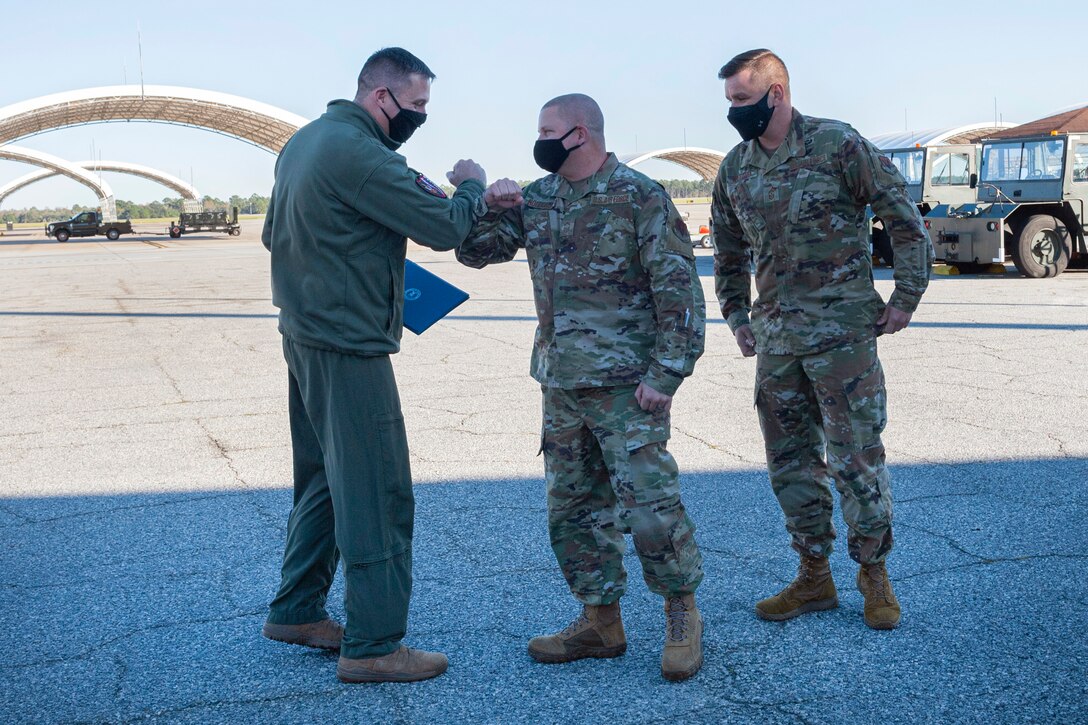 Photo of Col Walls bumping elbows with an Airman