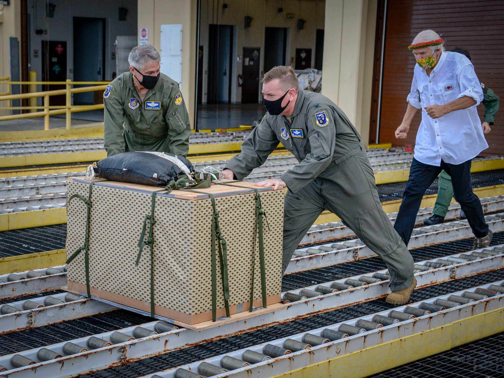 Brig. Gen. Jeremy Sloane, 36th Wing commander, and Col. Kevin Martin, 374th Operations Group commander, make the ceremonial “push” of the first pallet to kick-off Operation Christmas Drop at Andersen Air Force Base, Guam, Dec. 7, 2020.