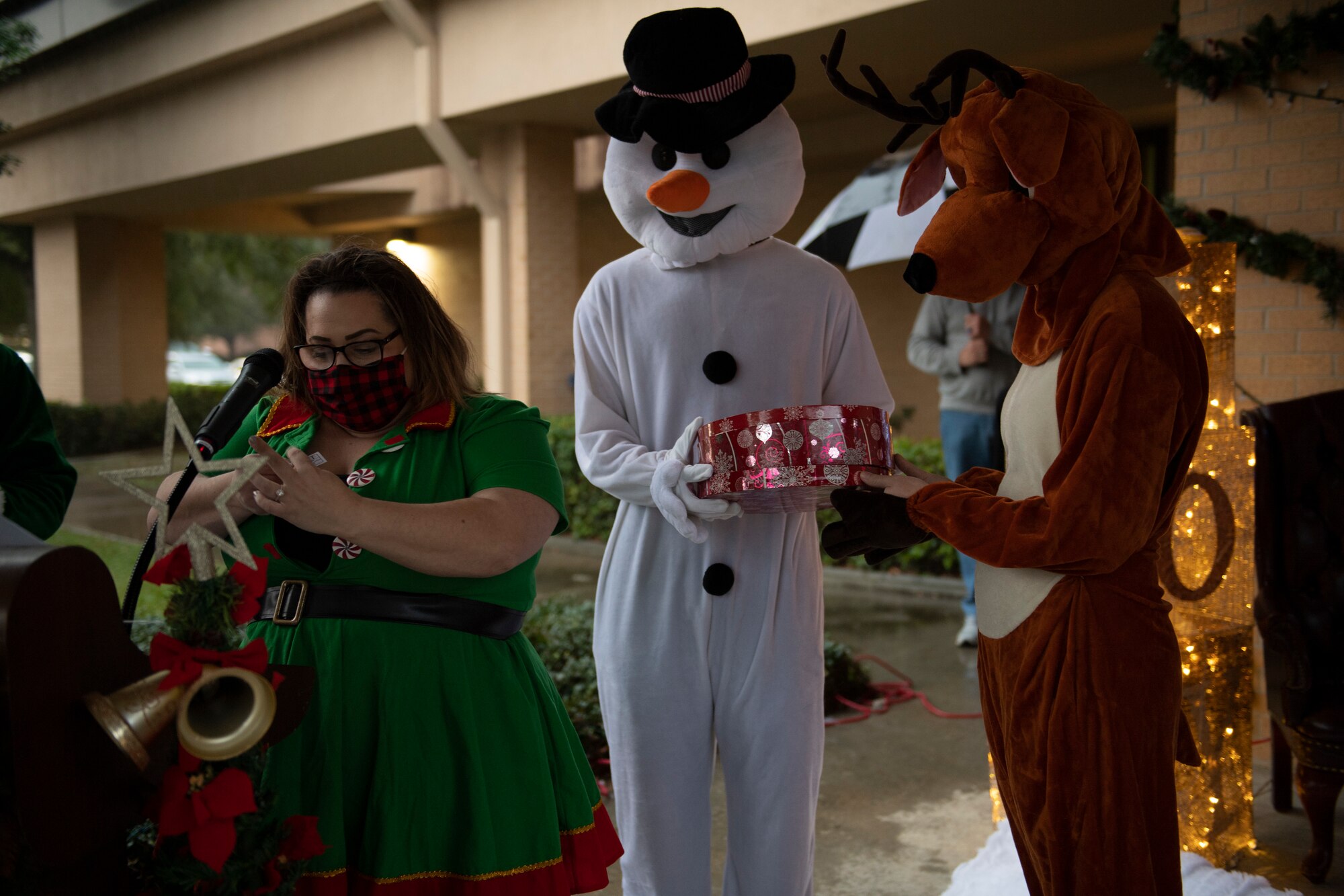 A photo of Sarah Pfau, a snowman costume and a reindeer costume, announcing the winners of a raffle during a virtual tree-lighting ceremony.