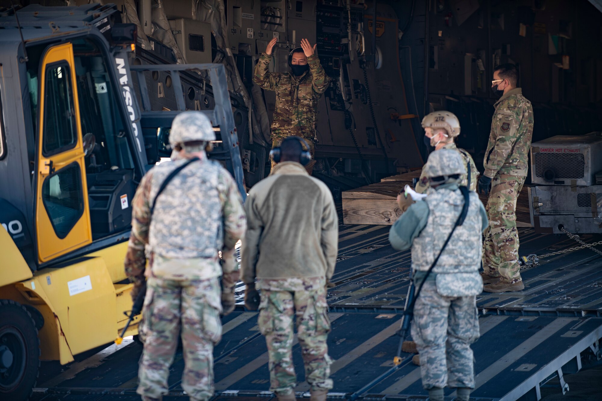 Airman unload a jammer from an aircraft.