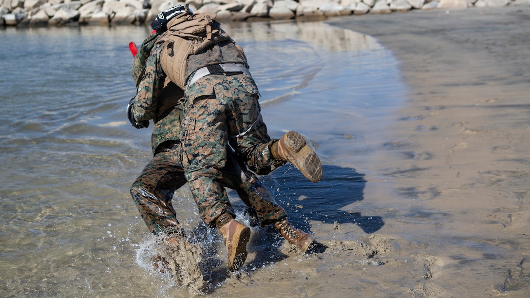 A U.S. Marine with 9th Communication Battalion, I Marine Expeditionary Force Information Group tackles his opponent during their Marine Corps Martial Arts Program (MCMAP) Instructor course culminating event at Marine Corps Base Camp Pendleton, California, Oct. 29, 2020. MCMAP trains Marines in unarmed combat, edged weapons, weapons of opportunity, and rifle and bayonet techniques. (U.S. Marine Corps photo by Lance Cpl. Marcus Melara)