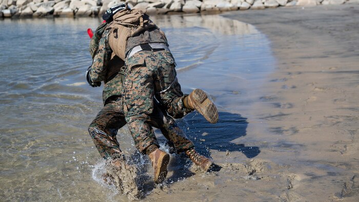 A U.S. Marine with 9th Communication Battalion, I Marine Expeditionary Force Information Group tackles his opponent during their Marine Corps Martial Arts Program (MCMAP) Instructor course culminating event at Marine Corps Base Camp Pendleton, California, Oct. 29, 2020. MCMAP trains Marines in unarmed combat, edged weapons, weapons of opportunity, and rifle and bayonet techniques. (U.S. Marine Corps photo by Lance Cpl. Marcus Melara)