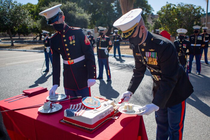 U.S. Marine Corps Cpl. Joshua Matson, left, a data systems administrator with I Marine Expeditionary Force Information Group (I MIG), and Col. Brian Rideout, commanding officer of I MIG, serve cake during a cake cutting ceremony at Marine Corps Base Camp Pendleton, California on Nov. 9, 2020. I MIG hosted the cake cutting ceremony in lieu of the Marine Corps 245th Birthday Ball to honor the long standing tradition of celebrating the birth date and legacy of the United States Marine Corps. (U.S. Marine Corps photo by Cpl. Tia D. Carr)