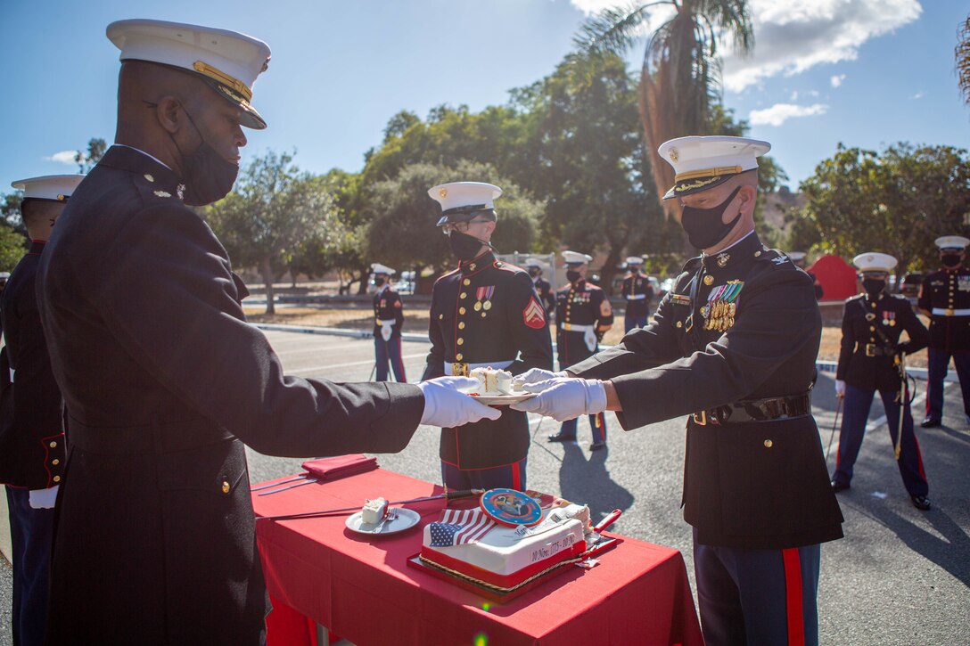 U.S. Marine Corps Maj. Keith Stevenson, left, commanding officer of I Marine Expeditionary Force Information Group (I MIG) Communication Strategy and Operations Company, receives the first slice of cake from Col. Brian Rideout, right, commanding officer of I MIG,  during a cake cutting ceremony at Marine Corps Base Camp Pendleton, California, Nov. 9, 2020. I MIG hosted the cake cutting ceremony in lieu of the Marine Corps 245th Birthday Ball to honor the long standing tradition of celebrating the birth date and legacy of the United States Marine Corps. (U.S. Marine Corps photo by Cpl. Tia D. Carr)