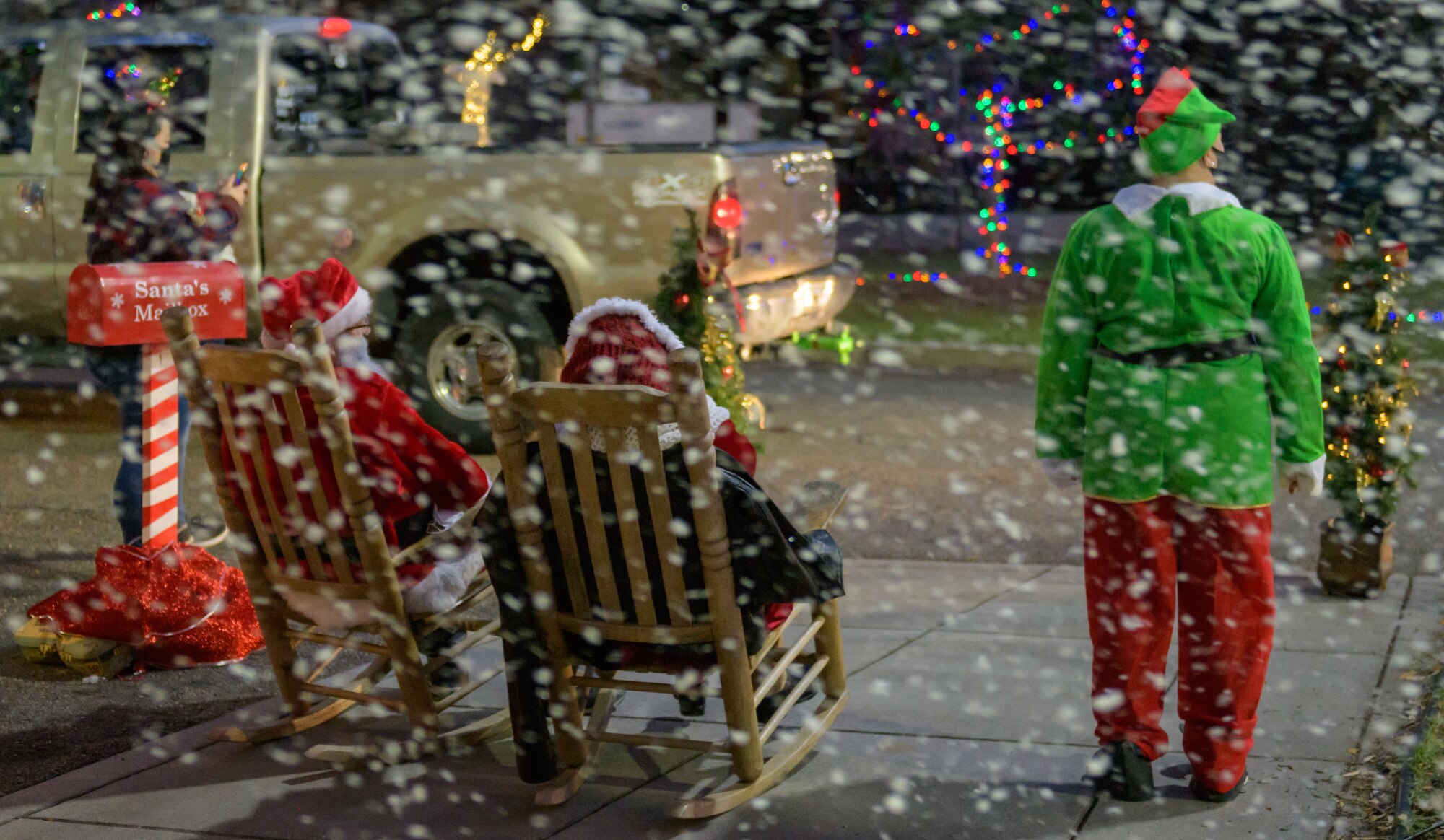 Santa Claus, Mrs. Claus and an elf wave to Keesler families as they drive by during Keesler's annual Christmas in the Park drive-thru celebration at Marina Park at Keesler Air Force Base, Mississippi, Dec. 4, 2020. The celebration, hosted by Outdoor Recreation, included light displays, hot chocolate and letters to Santa. (U.S. Air Force photo by Andre' Askew)