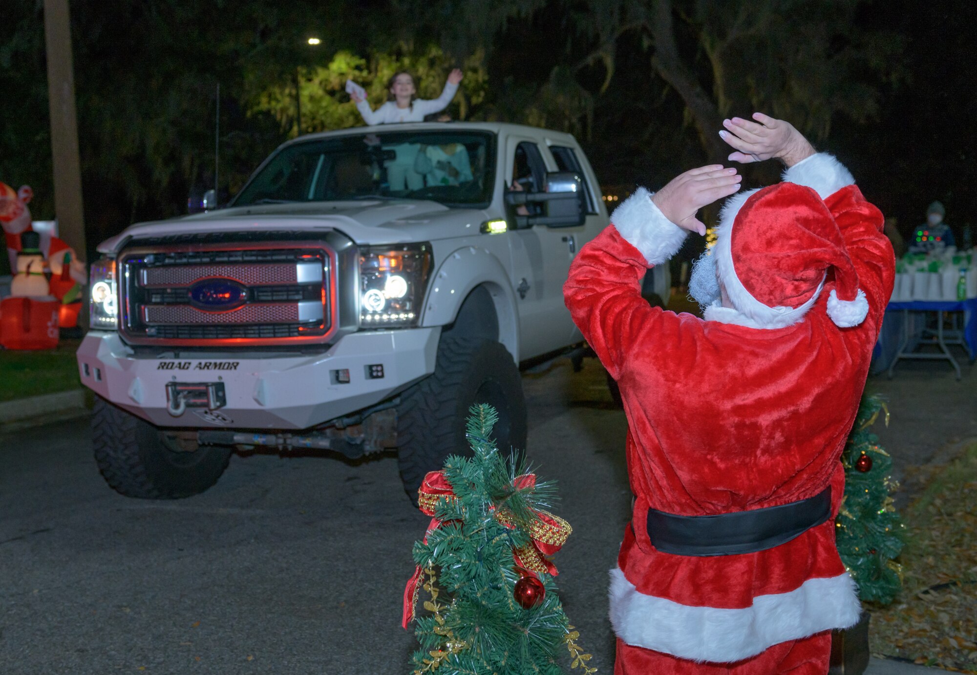 Santa Claus waves to Keesler families as they drive by during Keesler's annual Christmas in the Park drive-thru celebration at Marina Park at Keesler Air Force Base, Mississippi, Dec. 4, 2020. The celebration, hosted by Outdoor Recreation, included light displays, hot chocolate and letters to Santa. (U.S. Air Force photo by Andre' Askew)