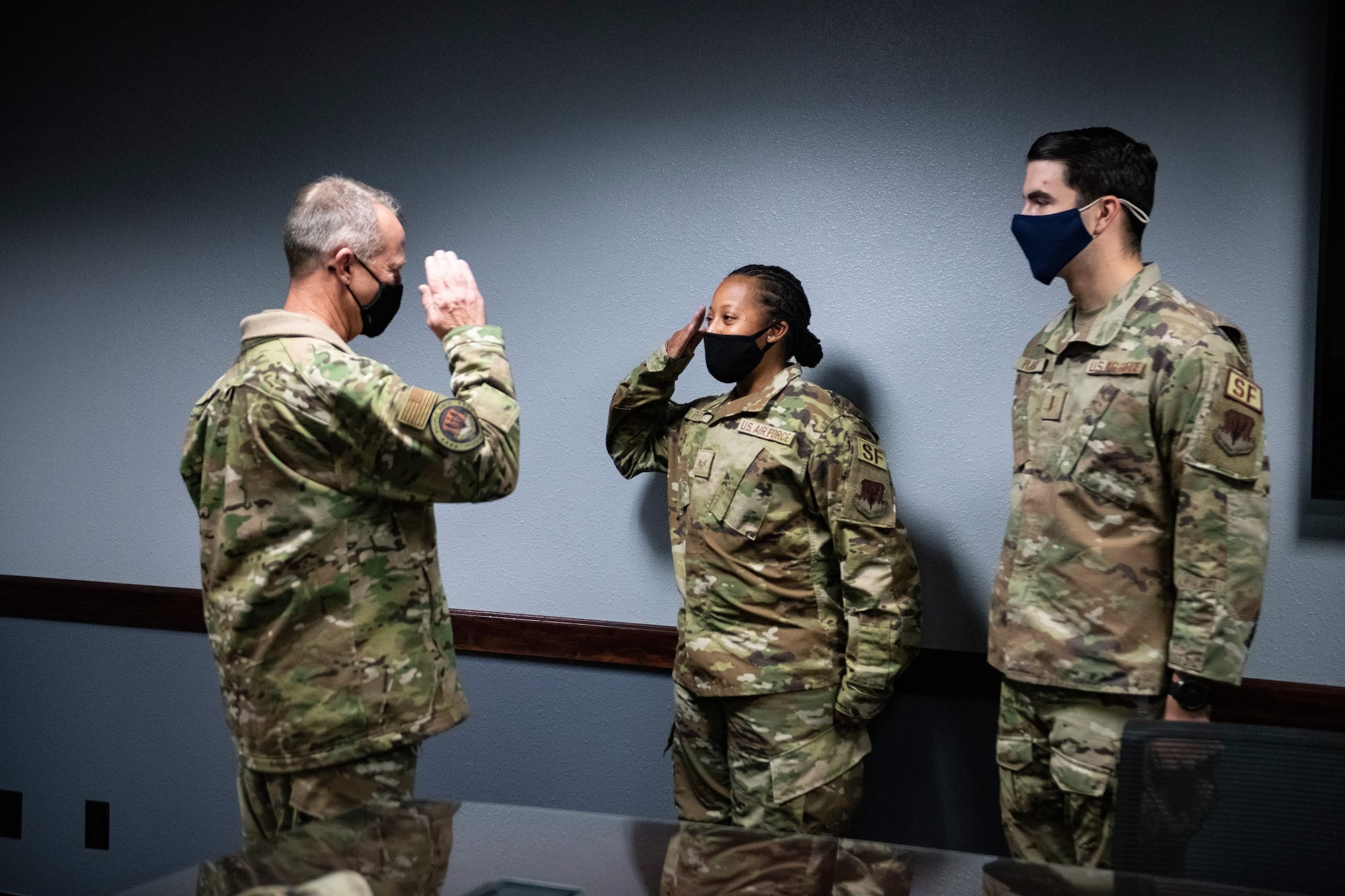 U.S. Air Force Gen. Mark Kelly, commander of Air Combat Command, left, coins Staff Sgt. Anesica Petty, 9th Security Forces Squadron, center, for her superior performance and recent achievements, Dec. 4, 2020, at Beale Air Force Base.