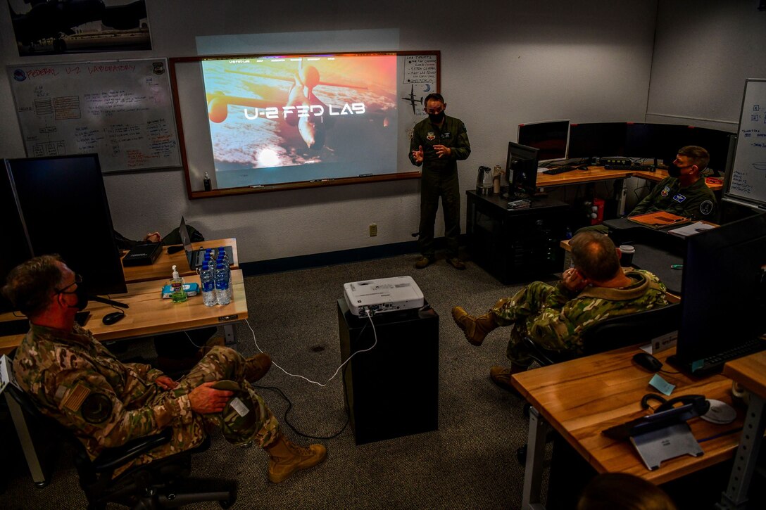 Maj. Raymond Tierney, U-2 Federal Laboratory director, center, briefs U.S. Air Force Gen. Mark Kelly, right, commander of Air Combat Command, and U.S. Air Force Command Chief Master Sgt. David Wade, Air Combat Command, about the organization’s stand-up and recent projects, Dec. 4, 2020, at Beale Air Force Base, California.