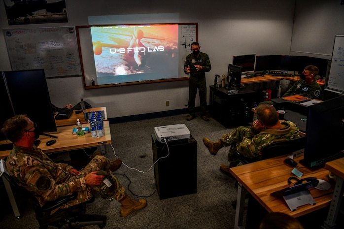 Maj. Raymond Tierney, U-2 Federal Laboratory director, center, briefs U.S. Air Force Gen. Mark Kelly, right, commander of Air Combat Command, and U.S. Air Force Command Chief Master Sgt. David Wade, Air Combat Command, about the organization’s stand-up and recent projects, Dec. 4, 2020, at Beale Air Force Base, California.