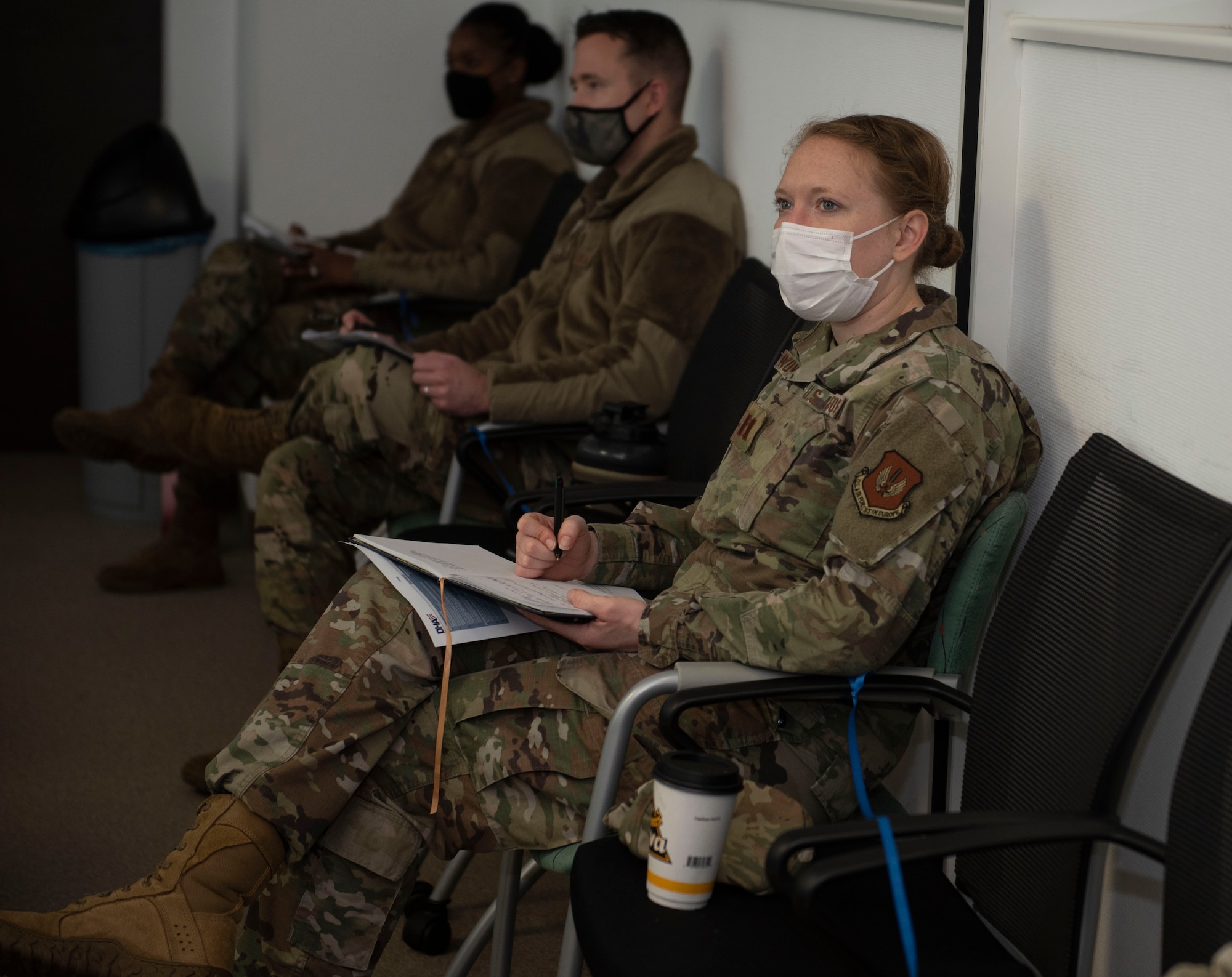 U.S. Air Force Capt. Erin Recanzone, 52nd Fighter Wing chief of public affairs, participates in a table-top exercise regarding the COVID-19 vaccine at Spangdahlem Air Base, Germany, Dec. 1, 2020. During the exercise members were able to maintain their physical distancing and wear masks, allowing them to safely participate and discuss a plan of action for the COVID-19 vaccine and how this will impact the 52nd FW along with surrounding geographically separated units. (U.S. Air Force photo by Senior Airman Melody W. Howley)