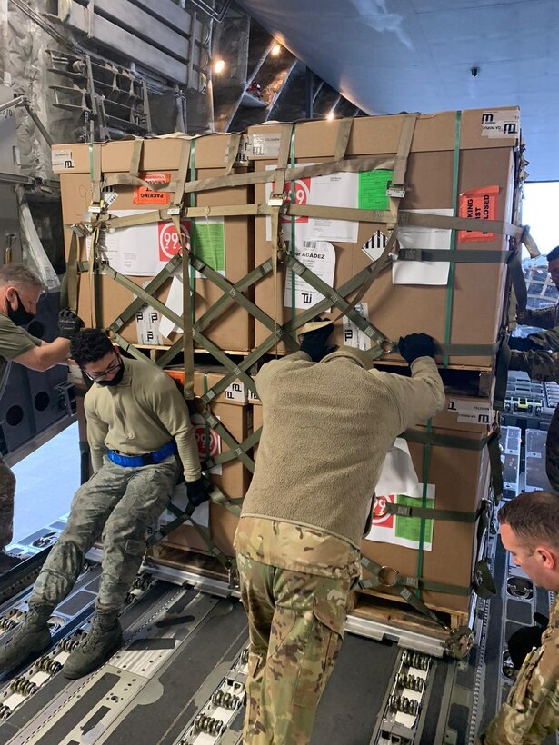 Airmen from the 721st Aerial Port Squadron push a pallet off an aircraft at Ramstein Air Base, Germany, Nov. 26, 2020.