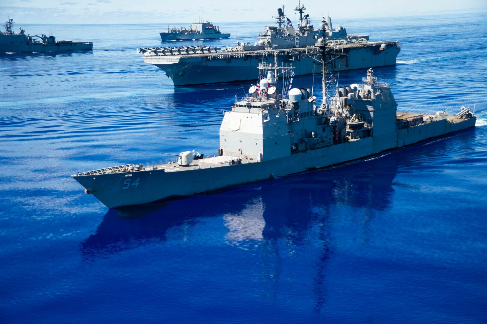 IMAGE: 200925-N-KP021-0313 PHILIPPINE SEA (Sept. 25, 2020) – USS Antietam (CG 54), USS American (LHA 6) and USNS Charles Drew (T-AKE 10) steam in formation in support of Valiant Shield 2020. Meanwhile, a team of Naval Surface Warfare Center Dahlgren Division (NSWCDD) scientists and engineers worked from two locations – Dahlgren, Va., and Honolulu, Hawaii – to ensure the success of this year’s Valiant Shield exercise. “Our biggest strategic accomplishment was supporting live forces, both afloat and at terrestrial sites, using a combined in-person and local operations team,” said Joseph Pack, NSWCDD deputy director for expeditionary warfare, regarding Dahlgren’s impact on the exercise that focuses on the integration of joint training in a blue-water environment among U.S. forces.   (U.S. Navy photo by Mass Communication Specialist 2nd Class Codie L. Soule)