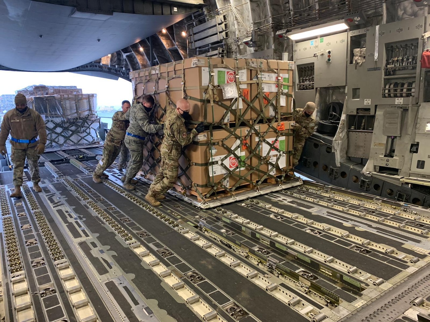 Airmen from the 721st Aerial Port Squadron push a pallet of rations onto a C-17 Globemaster III aircraft at Ramstein Air Base, Germany, Nov. 26, 2020.