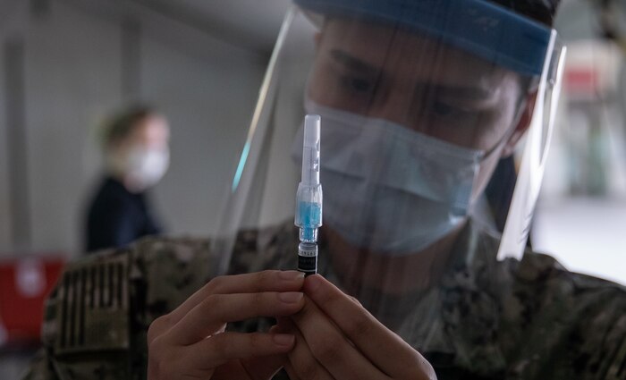 Seaman Jose Acosta prepares an influenza vaccine at Camp Foster, Okinawa, Japan, Nov. 25.
