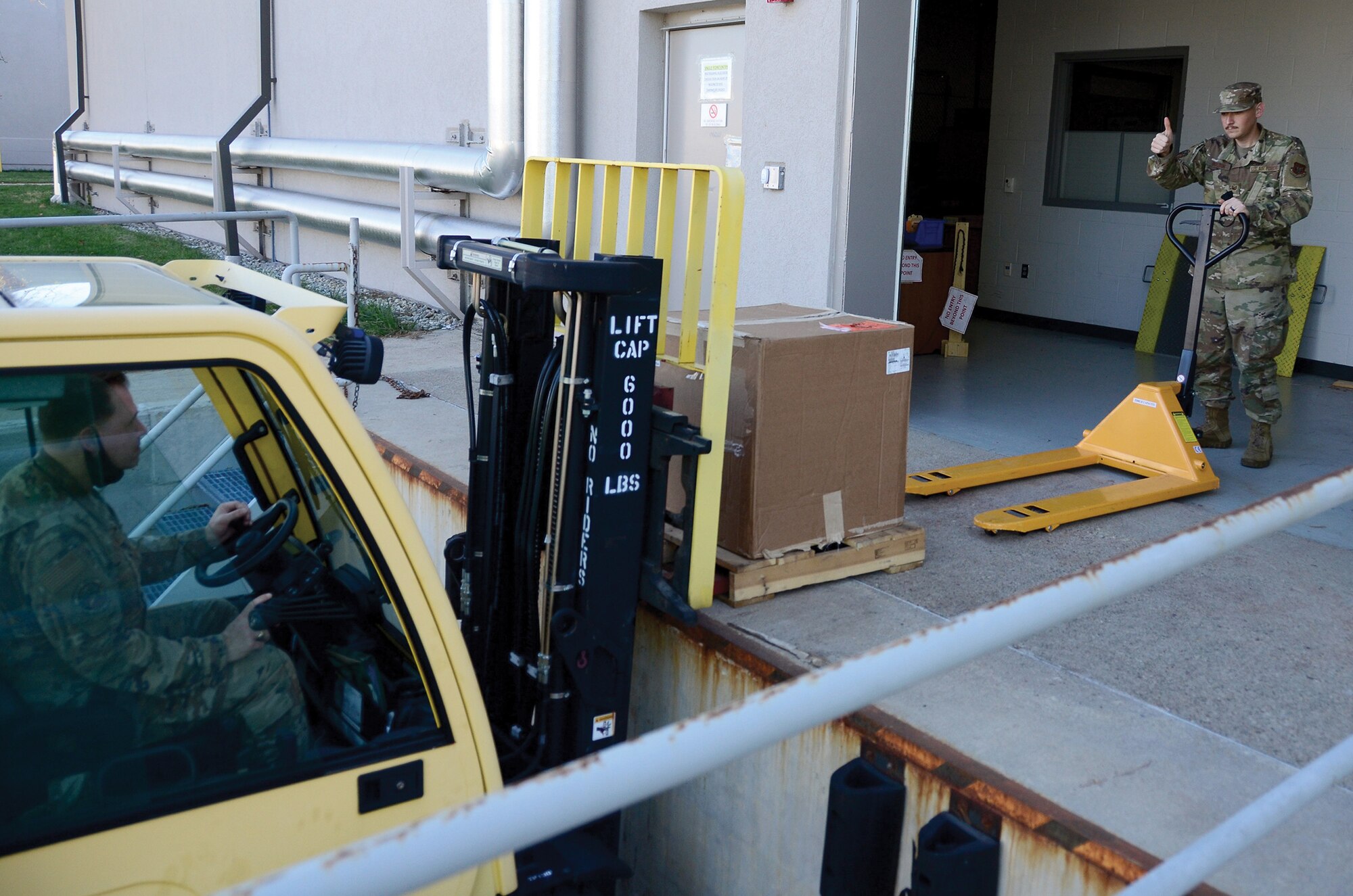 Tech. Sgt. Chris Clark, 445th Logistics Readiness Squadron material management craftsman, delivers an aircraft part to Tech. Sgt. Ethan Bolton, 445th LRS material management craftsman Nov. 7, 2020. (U.S. Air Force photo/Staff Sgt. Darrell Sydnor)