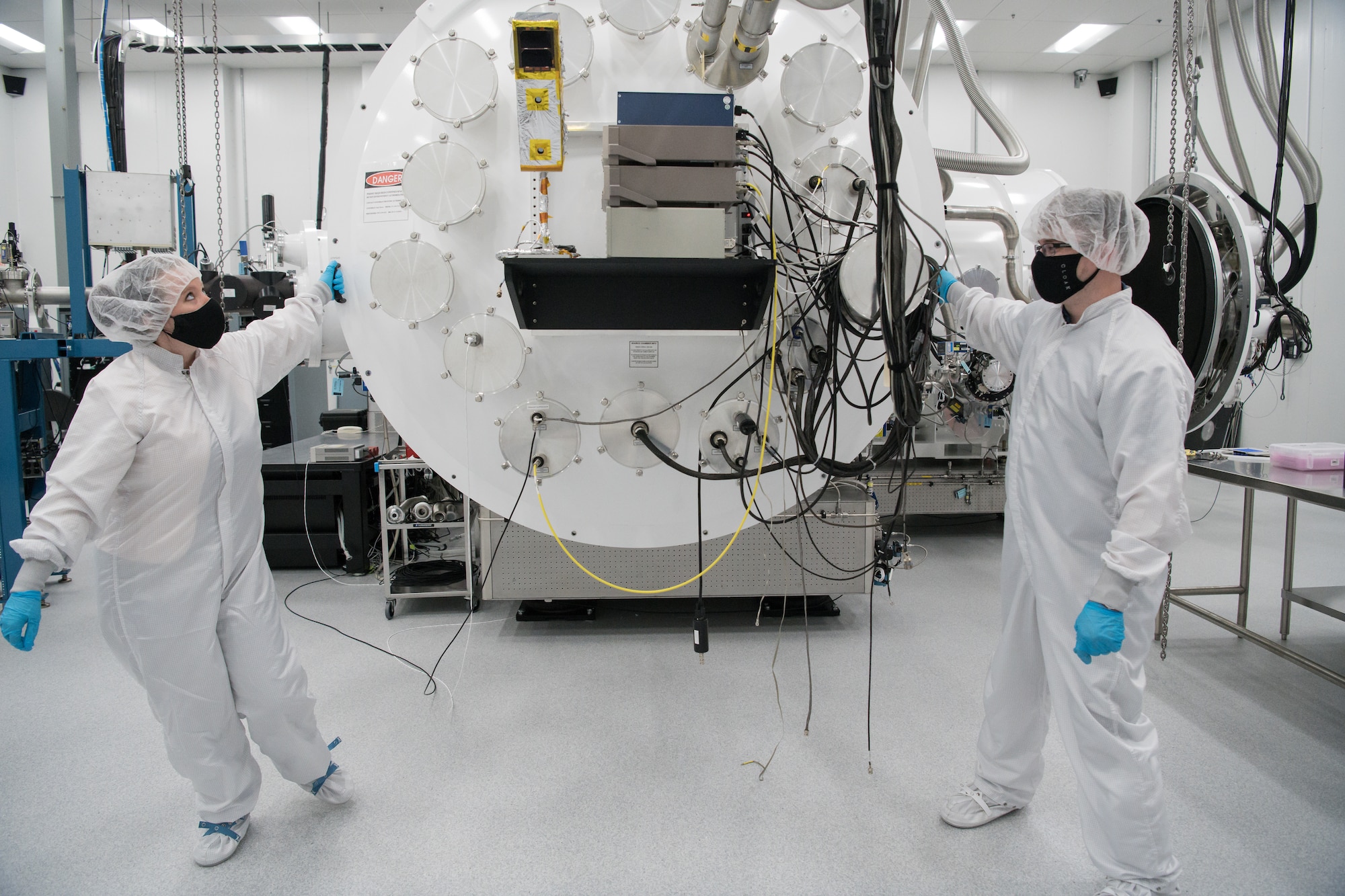 Kellye Burns, left, a space test engineer, and Eric D'Ambro, a test operations engineer, open the door of a Space Asset Resilience thermal vacuum chamber, Aug. 3, 2020, at Arnold Air Force Base, Tenn. The chamber is contained in a class 10,000 clean room. (U.S. Air Force photo by Jill Pickett)