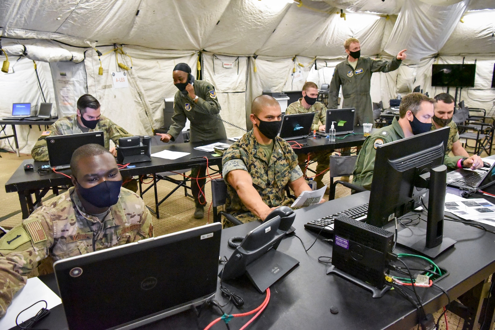 IMAGE: PEARL HARBOR (Sep. 23, 2020) Service members from the U.S. Navy, U.S. Marine Corps, U.S. Air Force, and U.S. Army work together in the Multi-domain Operations Center - Forward (MDOC-F) during exercise Valiant Shield 2020. Meanwhile, a team of Naval Surface Warfare Center Dahlgren Division (NSWCDD) scientists and engineers worked from two locations – Dahlgren, Va., and Honolulu, Hawaii – to ensure the success of this year’s Valiant Shield exercise. “Our biggest strategic accomplishment was supporting live forces, both afloat and at terrestrial sites, using a combined in-person and local operations team,” said Joseph Pack, NSWCDD deputy director for expeditionary warfare, regarding Dahlgren’s impact on the exercise that focuses on the integration of joint training in a blue-water environment among U.S. forces.  (U.S. Navy photo by Mass Communication Specialist 1st Class Nate Laird/Released)