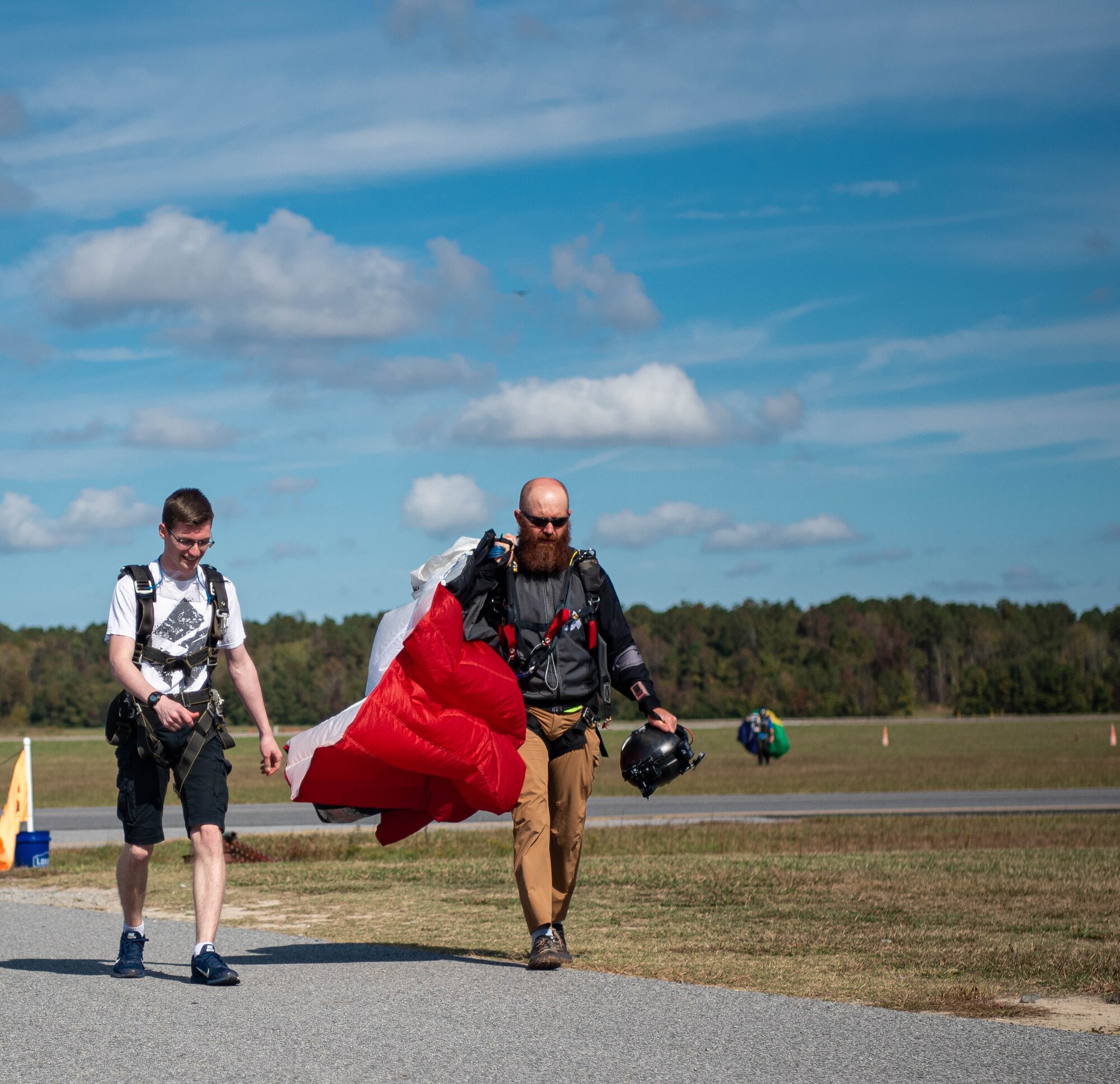 An Airmen walks back with his instructor after skydiving.