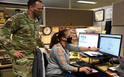 USAMMA’s pharmacy consultant and Distribution Operations Center, or DOC, Director Lt. Col. Todd Reeder receives an update from DOC Deputy Director Liz Andrews on the progress of the COVID-19 ordering system on Dec. 4, as the team receives COVID-19 vaccine orders from throughout the Department of Defense. In anticipation of the U.S. Food and Drug Administration’s emergency use authorization of a vaccine or multiple vaccines, the USAMMA team is collecting COVID-19 vaccine orders from all service branches and submitting them to the U.S. Centers for Disease Control and Prevention