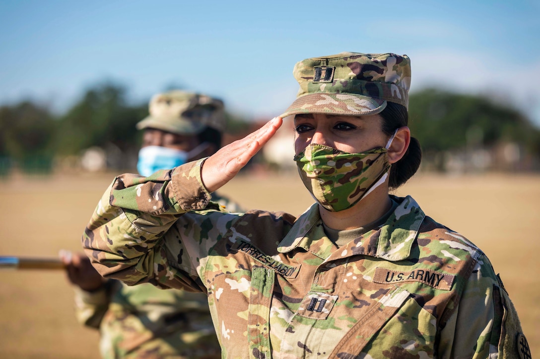 A soldier wearing a mask salutes.