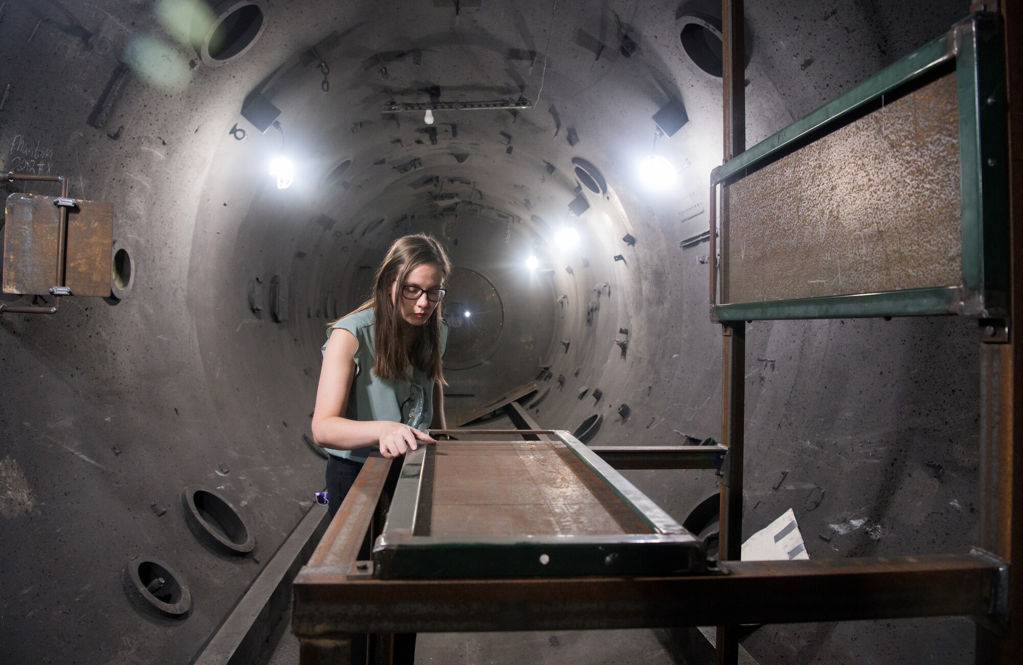 Bonni McKinney, test engineer for the Hypervelocity Flyout, Impact and Lethality Ground T&E capability, inspects frames used for capturing X-ray images of projectiles in Range G, July 21, 2020, at Arnold Air Force Base, Tenn. The range is instrumented to allow engineers to capture data about the flight of the projectiles. (U.S. Air Force photo by Jill Pickett)