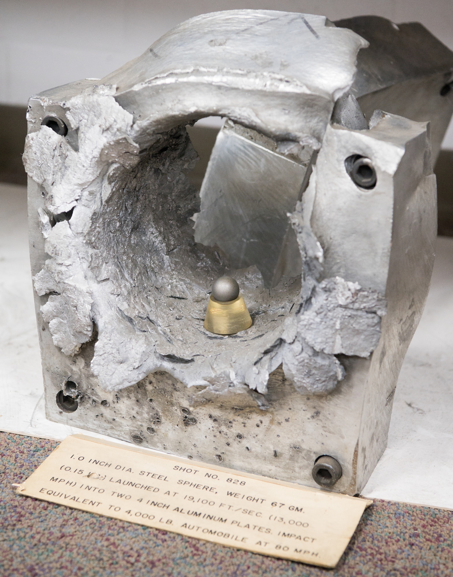 In the Hypervelocity Flyout, Impact and Lethality Ground Test and Evaluation capability at Arnold Air Force Base, Tenn., the results of firing a 1-inch steel ball at 4-inch thick aluminum plates is clearly visible. The ball and one of the plates are seen in this image taken July 21, 2020. (U.S. Air Force photo by Jill Pickett)