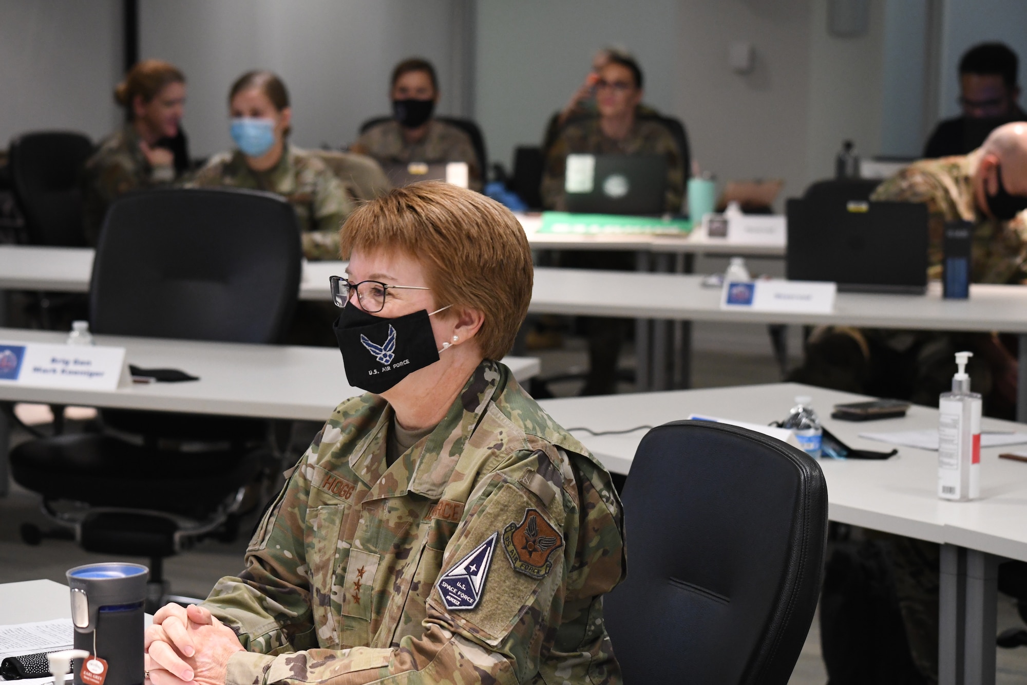 Image of an Airman sitting at a table wearing a mask.