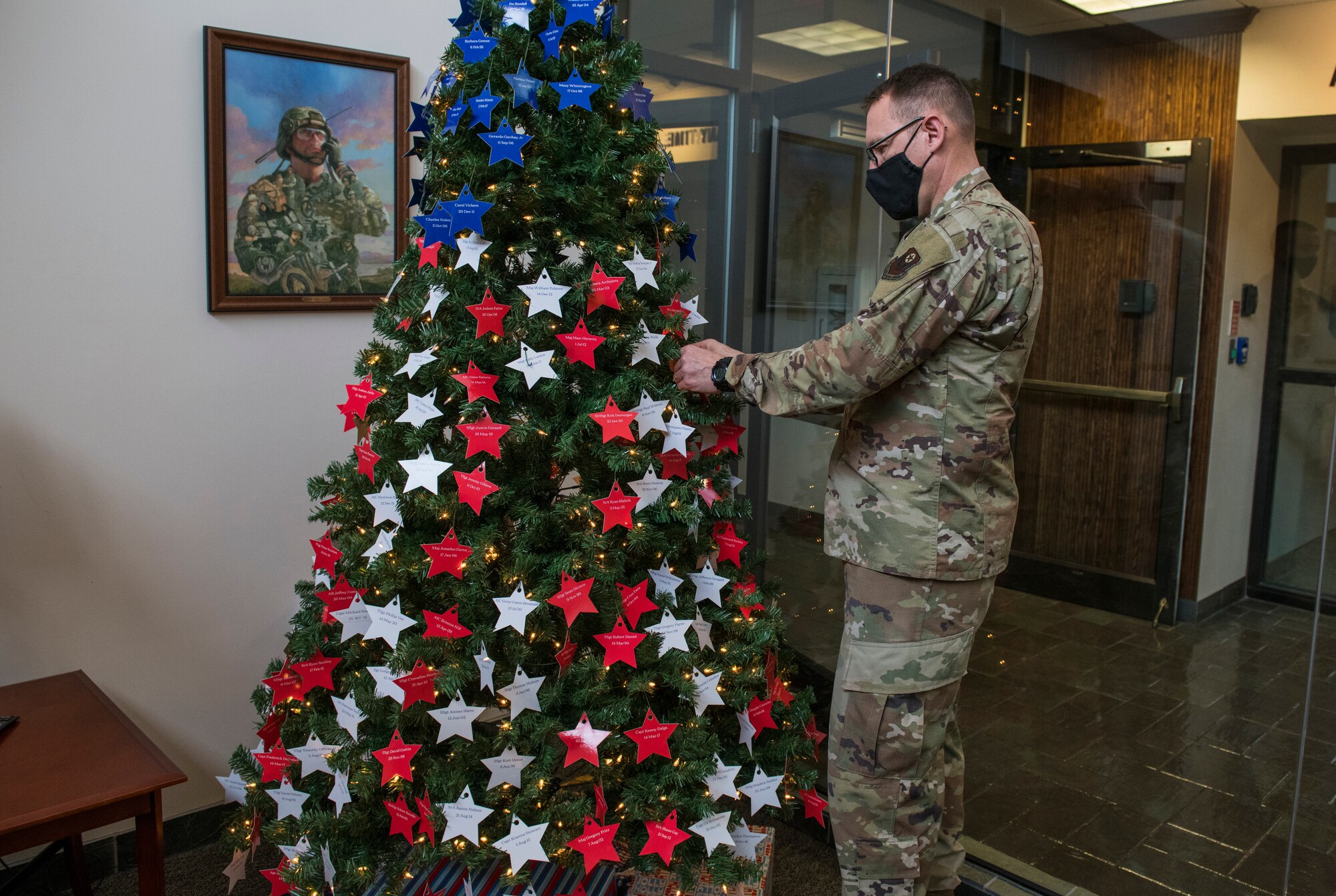 U.S. Air Force Chief Master Sgt. John Lang, superintendent of the 1st Special Operations Maintenance Group, places stars on an Honor Tree.