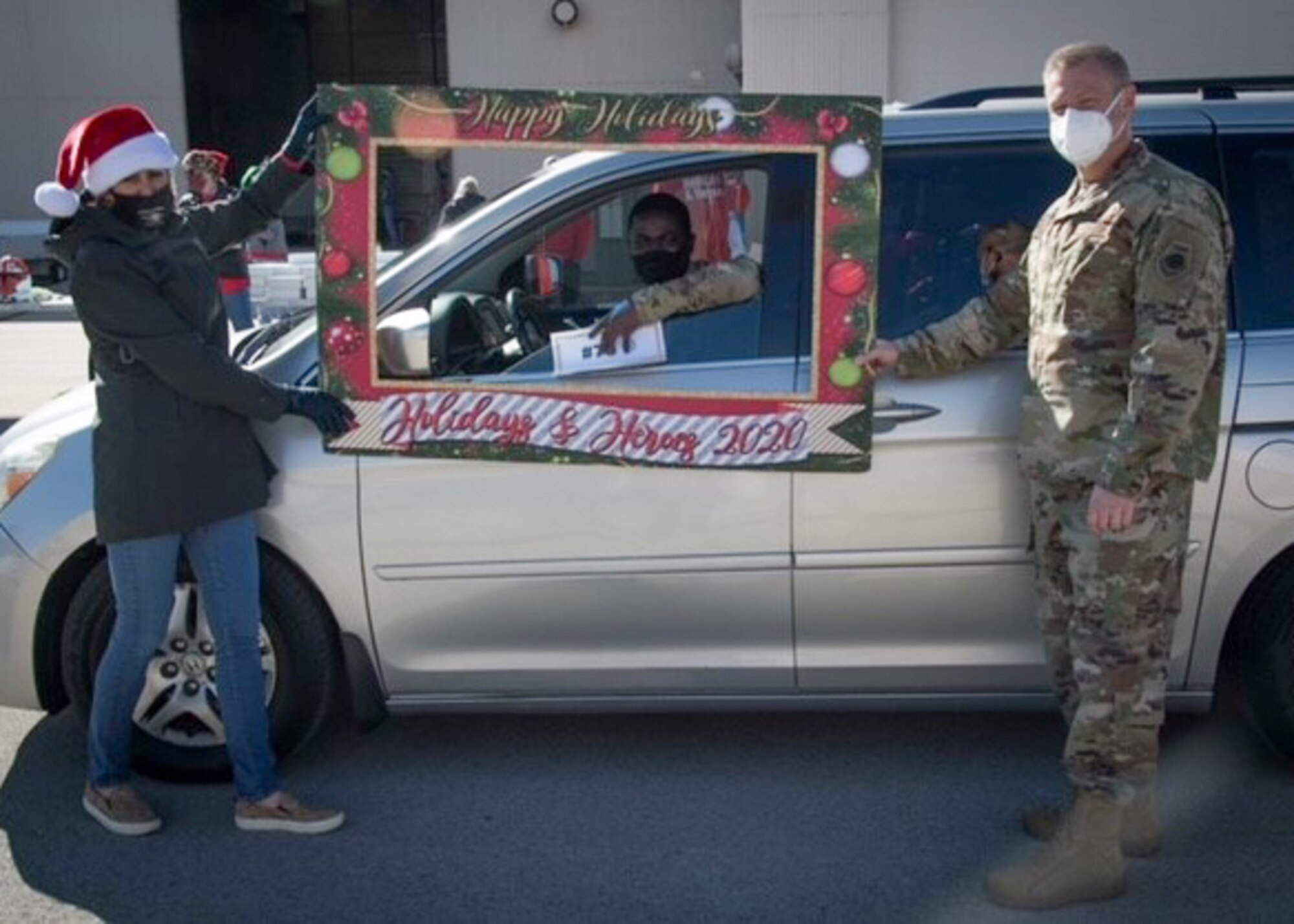 (Left) Mrs. Anne Pottinger, Fort Worth community leader, and Col. Allen Duckworth (right), 301st Fighter Wing commander, participate in the drive-thru Holidays & Heroes event Sunday, Dec. 6, 2020, at U.S. Naval Air Station Joint Reserve Base Fort Worth, Texas. The annual Holidays & Heroes event, which connects community members and businesses with military families who could use a little extra help during the holiday season, assisted more than 105 families from the Navy, Marines, and Air Force this year. (U.S. Air Force photo by Senior Airman William Downs)