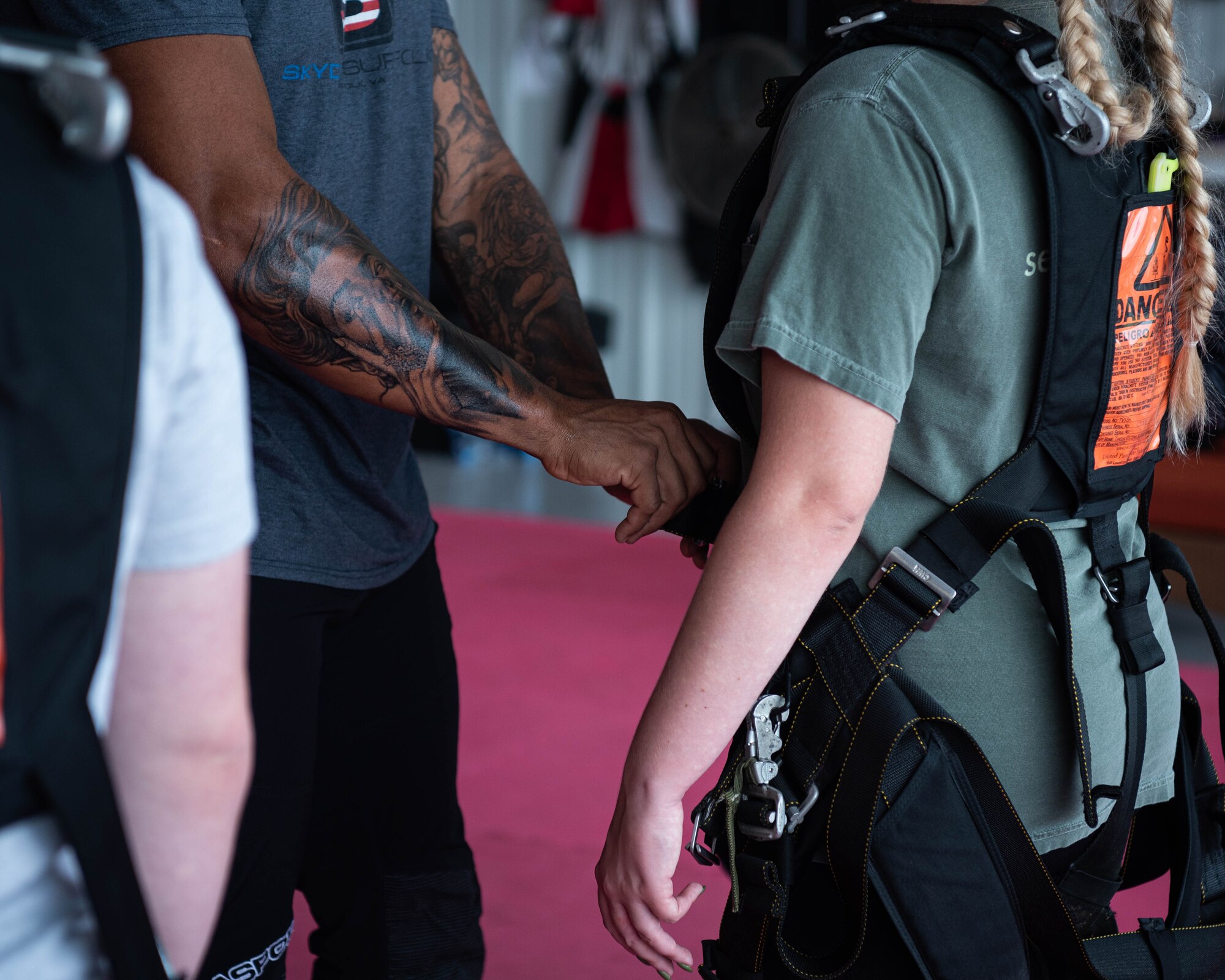 An Airman is fitted for a harness before going skydiving.