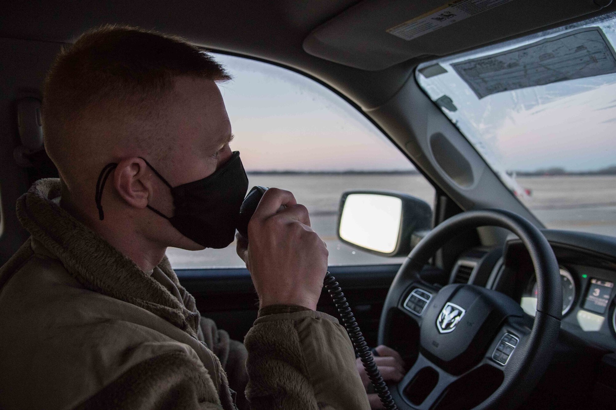 Airman 1st Class Douglas Bosarge, 22nd Operations Support Squadron airfield management journeyman, radios the air traffic control tower prior to crossing the runway Dec. 4, 2020, at McConnell Air Force Base, Kansas. The Airfield Management shop is responsible for the maintenance of runways, lighting and integrity of the airfield, ensuring safe conditions for aircraft landings and departures. (U.S. Air Force photo by Senior Airman Alexi Bosarge)