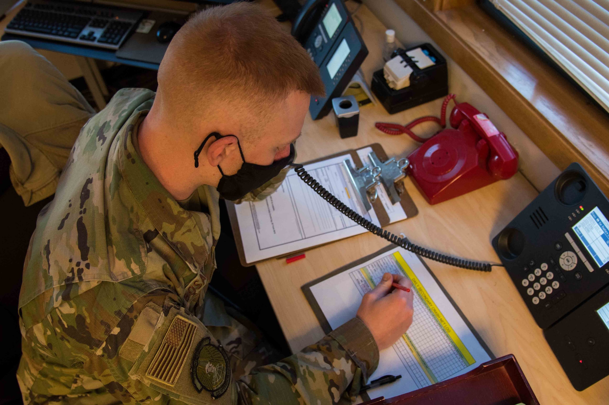 Airman 1st Class Douglas Bosarge, 22nd Operations Support Squadron airfield management journeyman, performs a daily primary crash alert system check Dec. 4, 2020, at McConnell Air Force Base, Kansas. The crash phone is used to call a list of agencies during a real-world emergency, which allows first responders to report to any ground or air emergency in a timely manner. (U.S. Air Force photo by Senior Airman Alexi Bosarge)