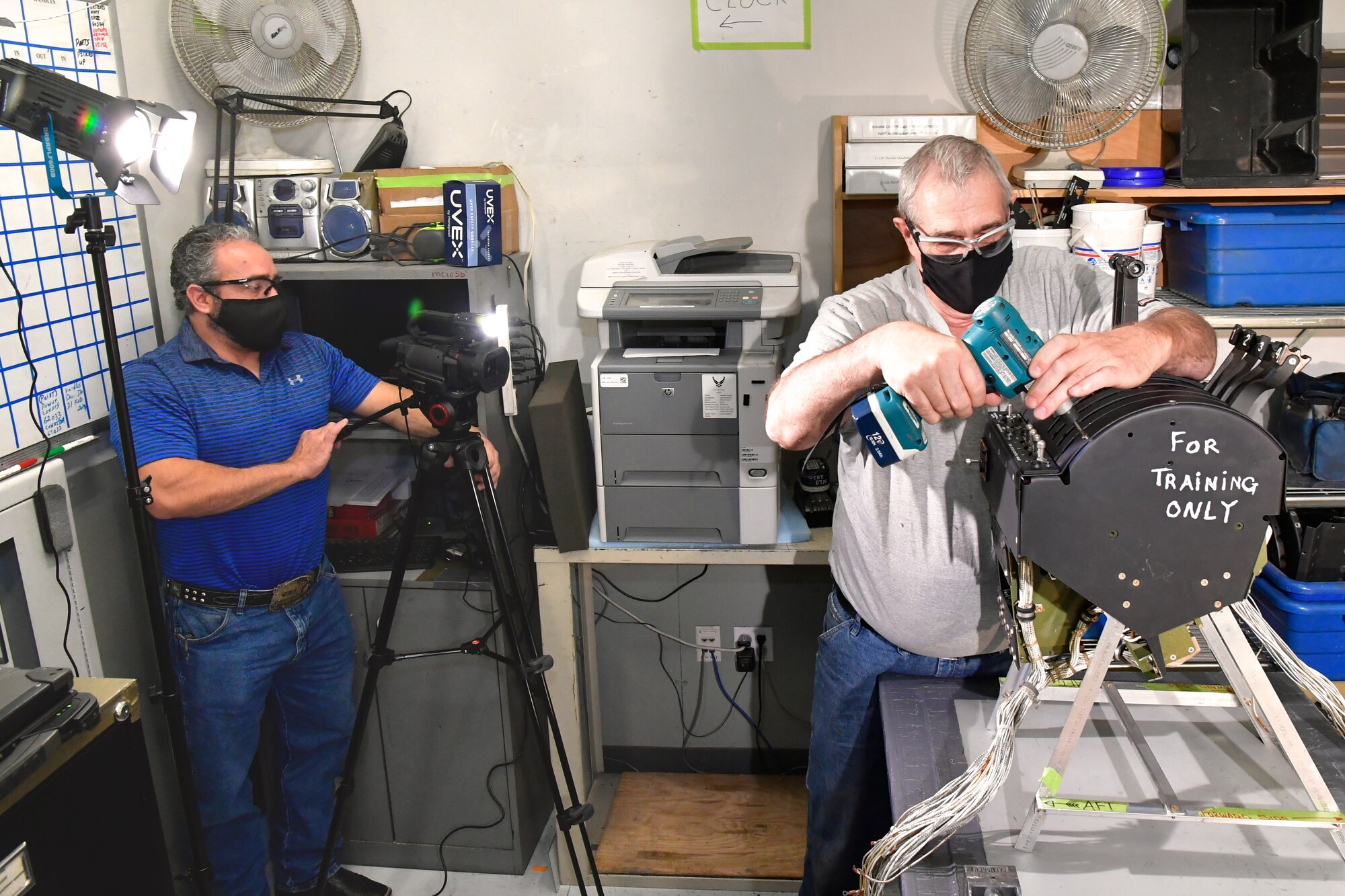 (Left to right) Scott Stokes, OO-ALC/OBH, Training office, films Trent Mikesell, C-130 Aircraft Mechanic, 309th AMXG, demonstrating work on an engine control quadrant during the making of a training video, Dec. 7, 2020, Hill Air Force Base, Utah.