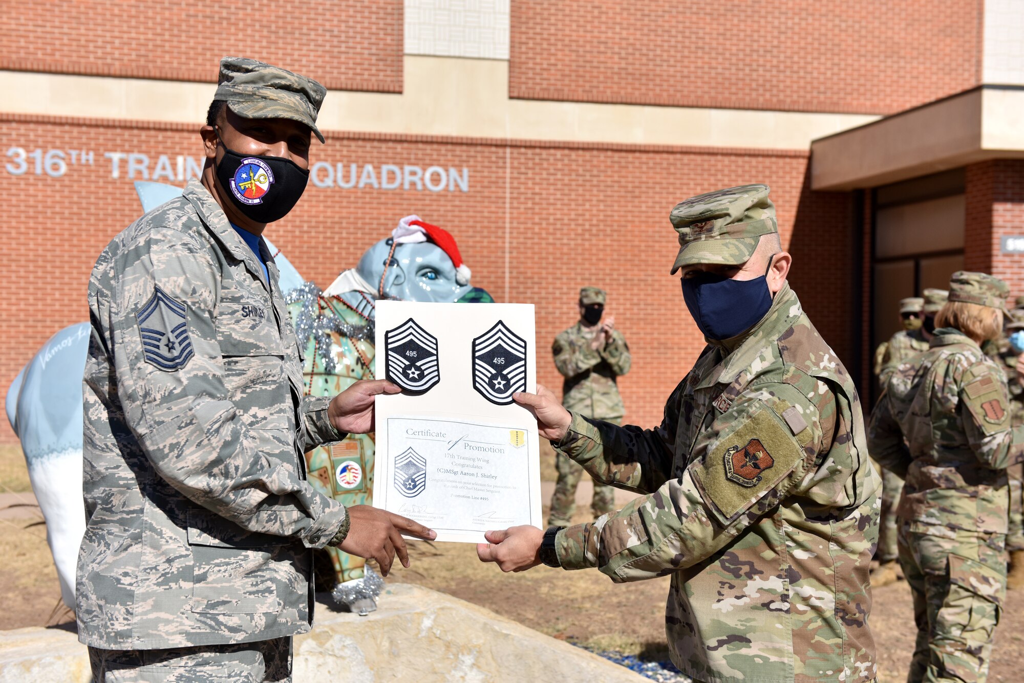 U.S. Air Force Col. Andres Nazario, 17th Training Wing commander, presents Chief Master Sgt. select Aaron Shirley, 316th Training Squadron superintendent, with stripes and a certificate with his line number at the 316th TRS on Goodfellow Air Force Base, Texas, Dec. 4, 2020. Chief master sergeants serve as key leaders at all levels in the Air Force. (U.S. Air Force photo by Staff Sgt. Seraiah Wolf)