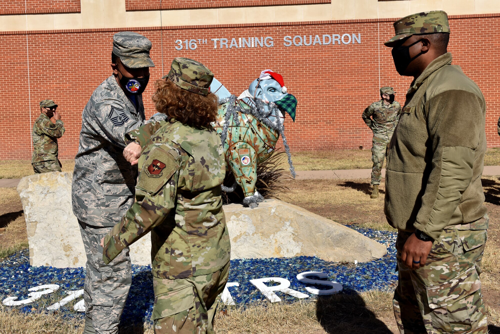 U.S. Air Force Col. Lillian Prince, 17th Training Wing individual mobilization augmentee to the commander, and Chief Master Sgt. Charmane Tatum, 17th Training Group superintendent, congratulate Chief Master Sgt. select Aaron Shirley, 316th Training Squadron superintendent, in front of the 316th TRS on Goodfellow Air Force Base, Texas, Dec. 4, 2020. Shirley arrived to Goodfellow as a master sergeant and has earned his chief stripe in three years. (U.S. Air Force photo by Staff Sgt. Seraiah Wolf)