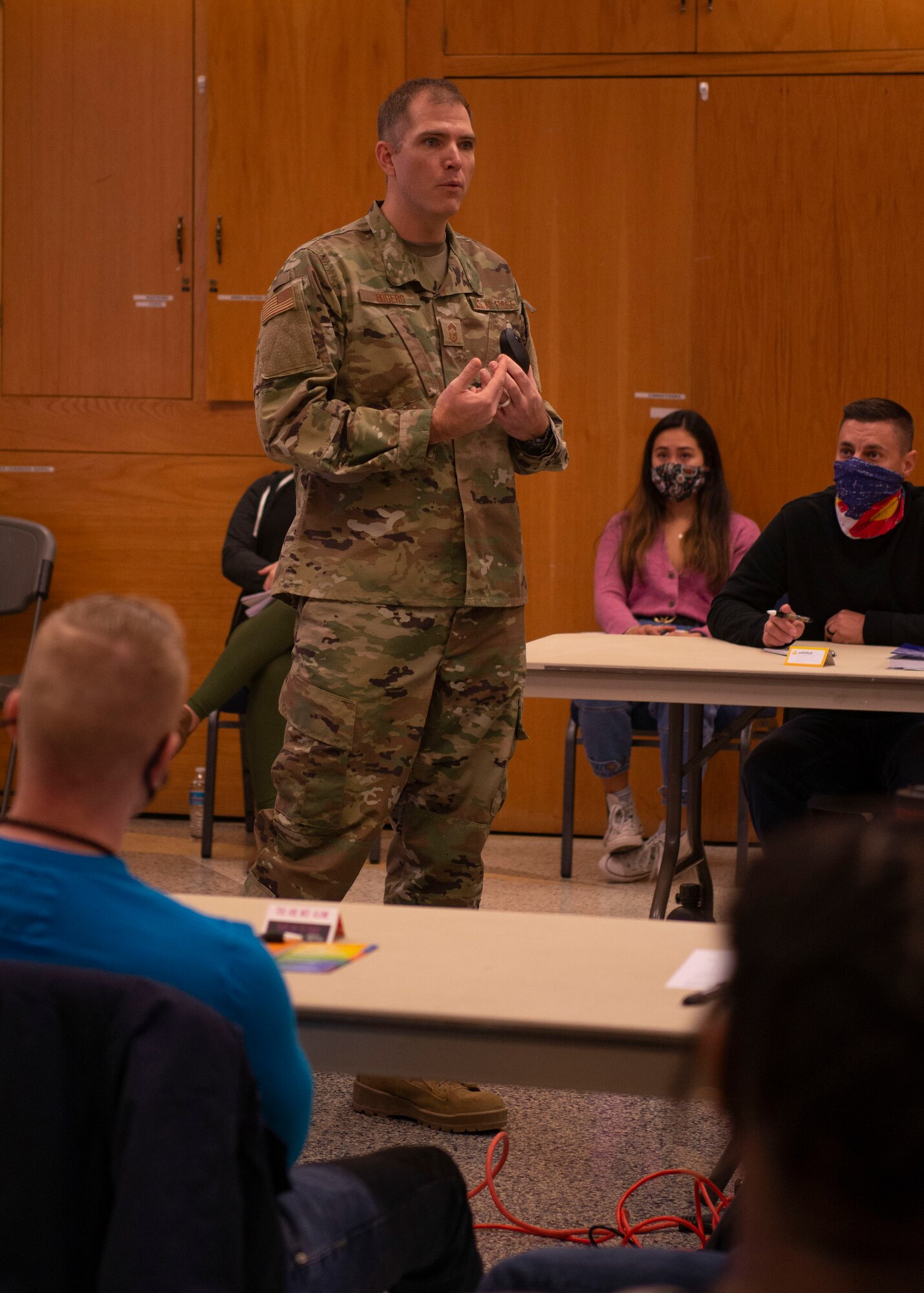Person addressing groups of people sitting at tables.