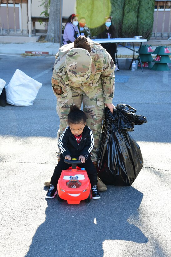 Staff Sgt. Tatianna Thomas, 926 Force Support Squadron services specialist, lets her son, Michael Johnson, take his new car for a ride during the Airman and Family Readiness Operation Holiday Hope event, Dec. 5, 2020, Nellis Air Force Base, Nev. (U.S. Air Force Photo by Staff Sgt. Paige Yenke)