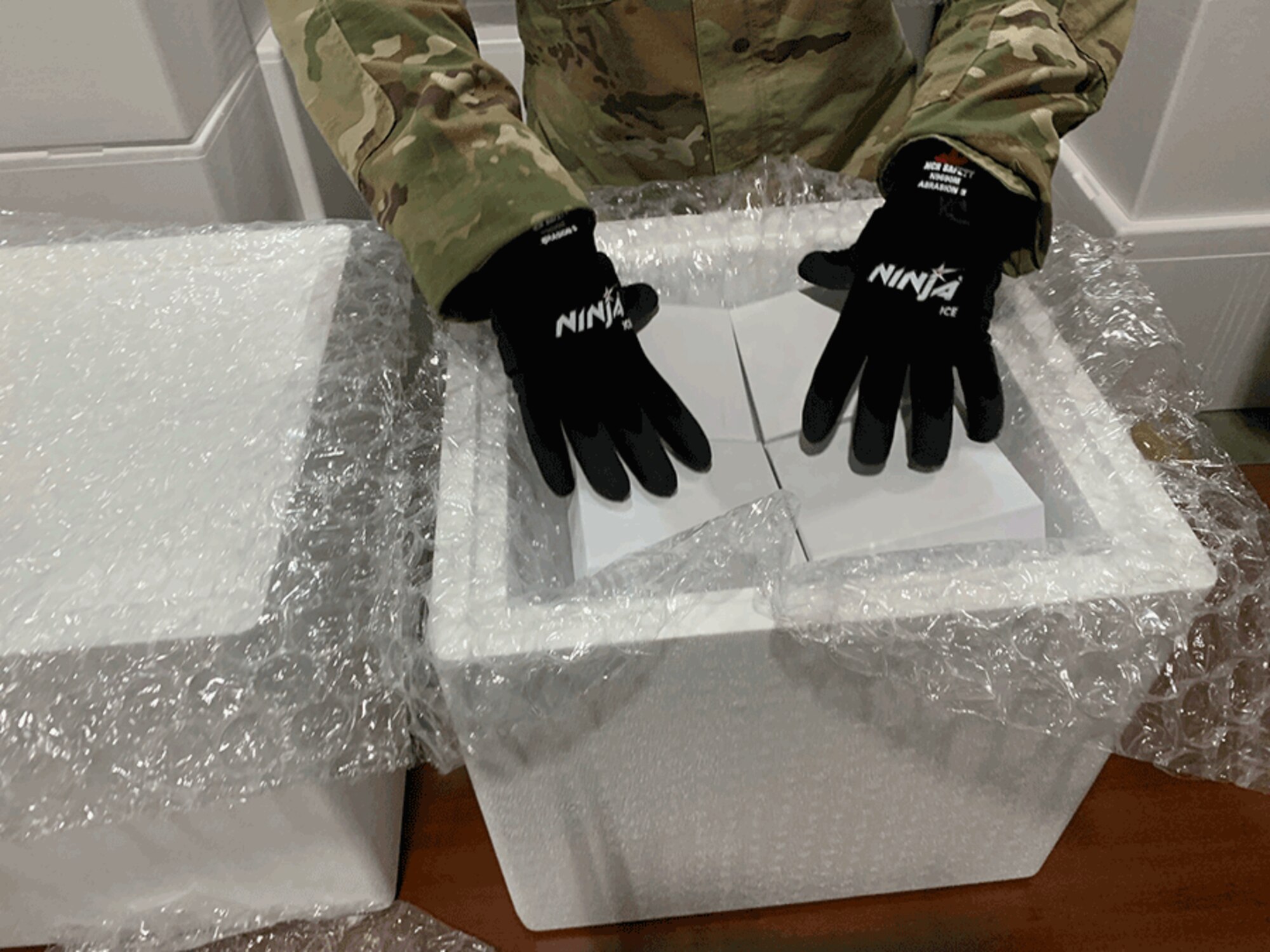 An Ohio National Guard member wears special gloves while practicing to pack glass vials in dry ice in preparation for when Ohio begins receiving the COVID-19 vaccine. About two dozen Ohio National Guard members have been working with the Ohio Department of Health to develop the logistics plan to receive and repackage the vaccine for distribution.