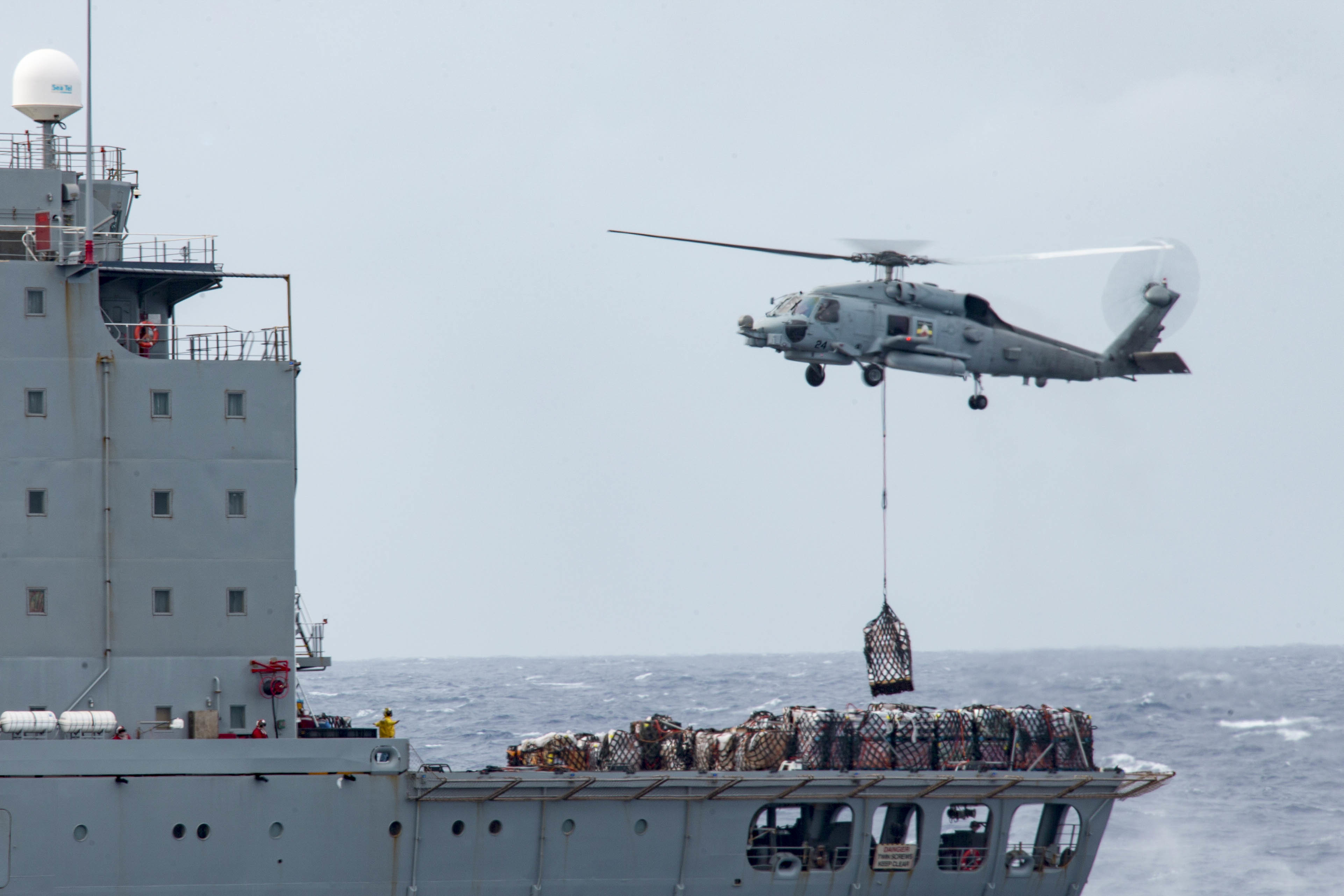 A U.S. Navy MH-60R Sea Hawk airlifts supplies from the Military Sealift Command fleet replenishment oiler USNS Guadalupe (T-AO 200) during a replenishment-at-sea.