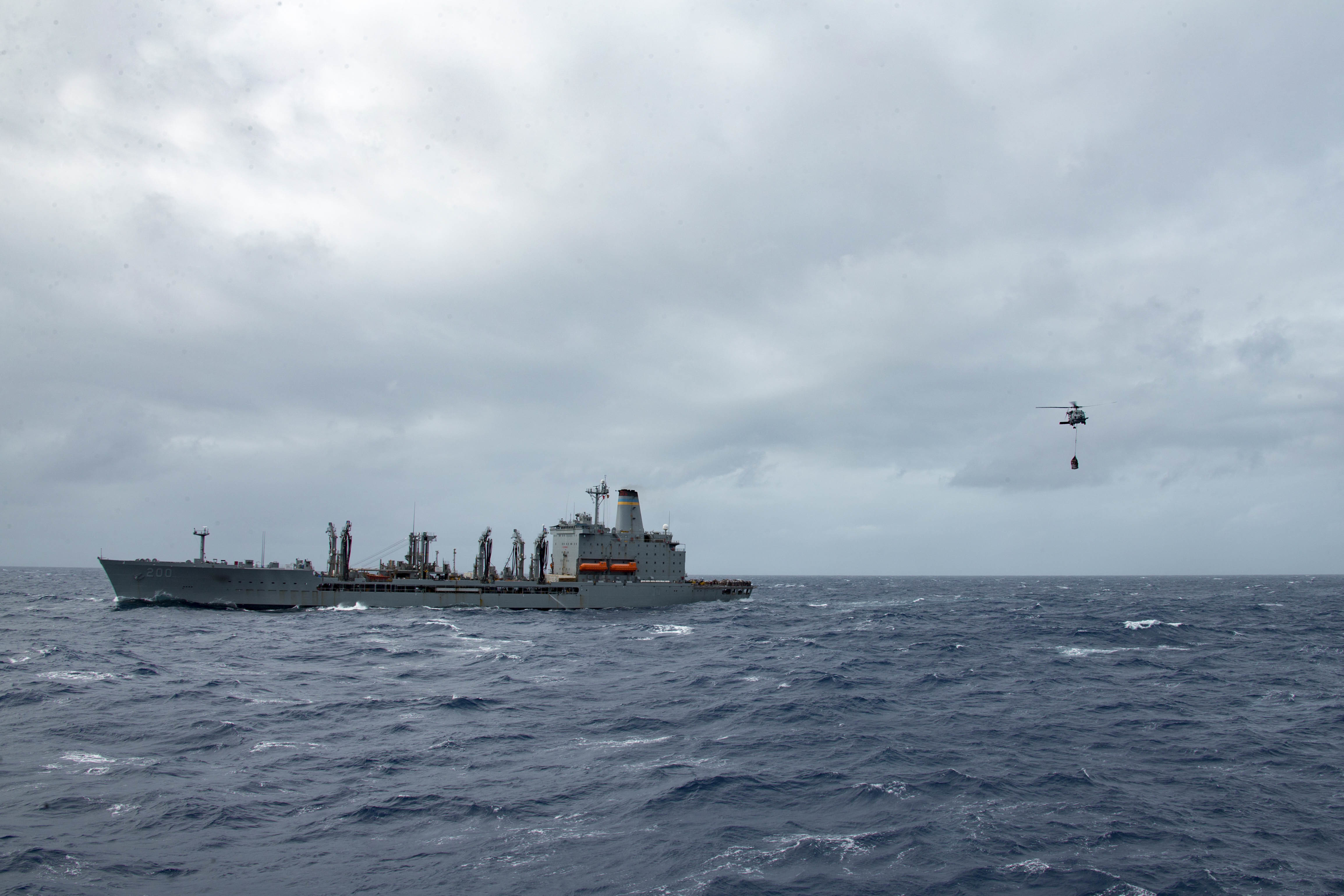 A U.S. Navy MH-60R Sea Hawk airlifts supplies from the Military Sealift Command fleet replenishment oiler USNS Guadalupe (T-AO 200) during a replenishment-at-sea.