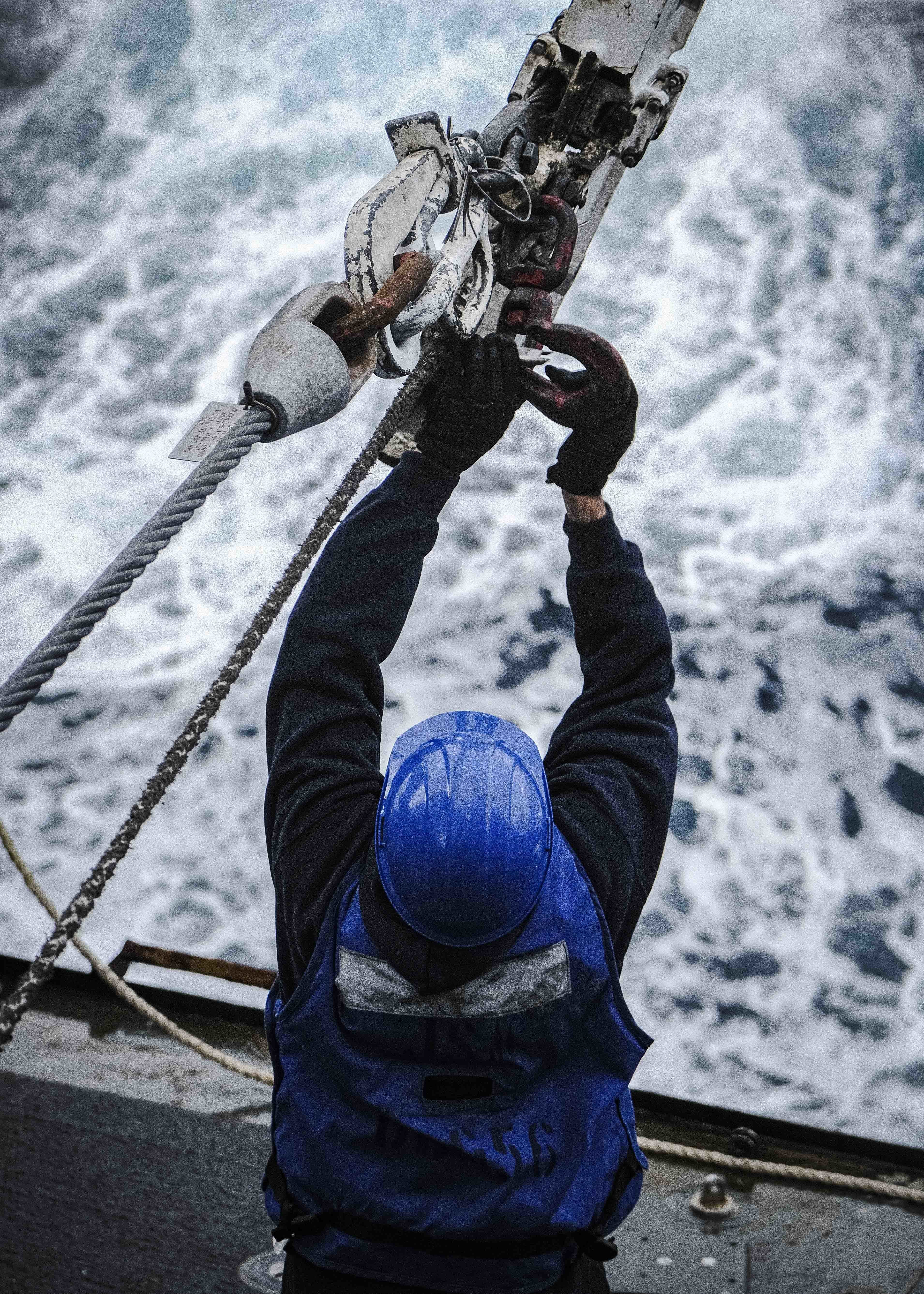 Logistics Specialist 3rd Class Tanner Martin, from Bakersfield, Calif., detaches a traveling surf hook aboard the Arleigh Burke-class guided-missile destroyer USS John S. McCain (DDG 56) during a replenishment-at-sea with the Lewis and Clark-class dry cargo and ammunition ship USNS Charles Drew (T-AKE 10).